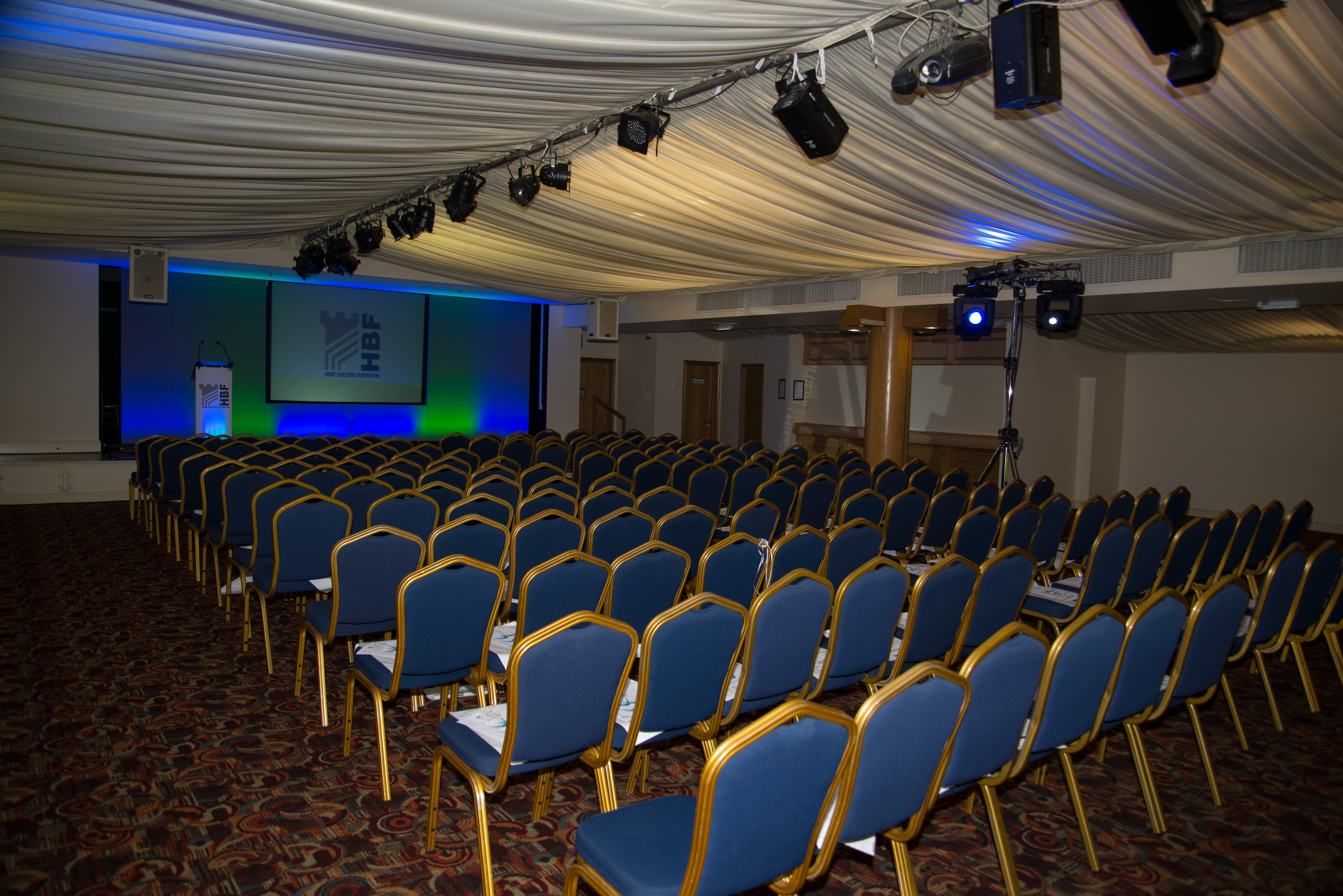 Conference room at The Marquee, DW Stadium, with blue chairs for events and presentations.