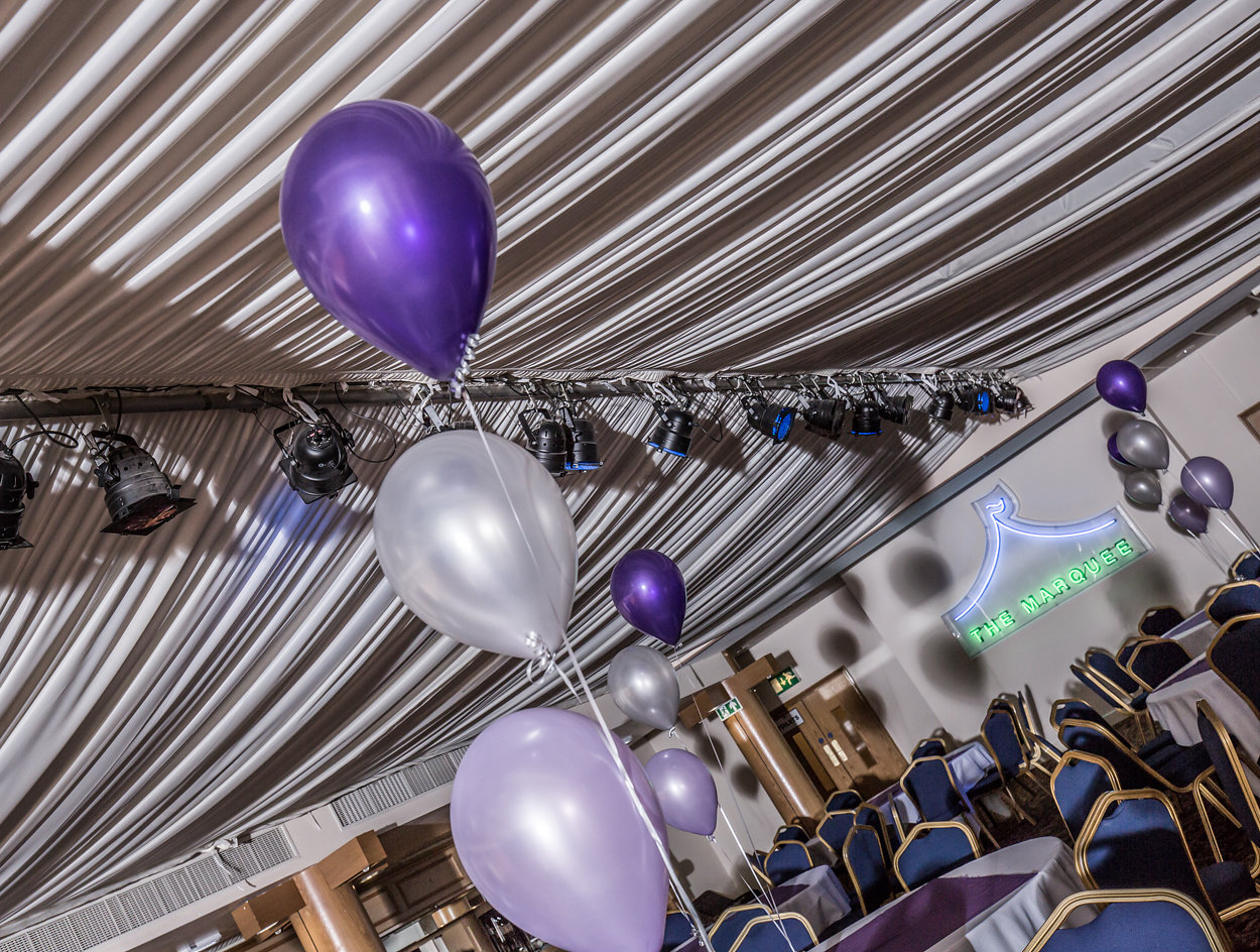 Elegant event space at The Marquee, featuring purple and silver decor for gatherings.