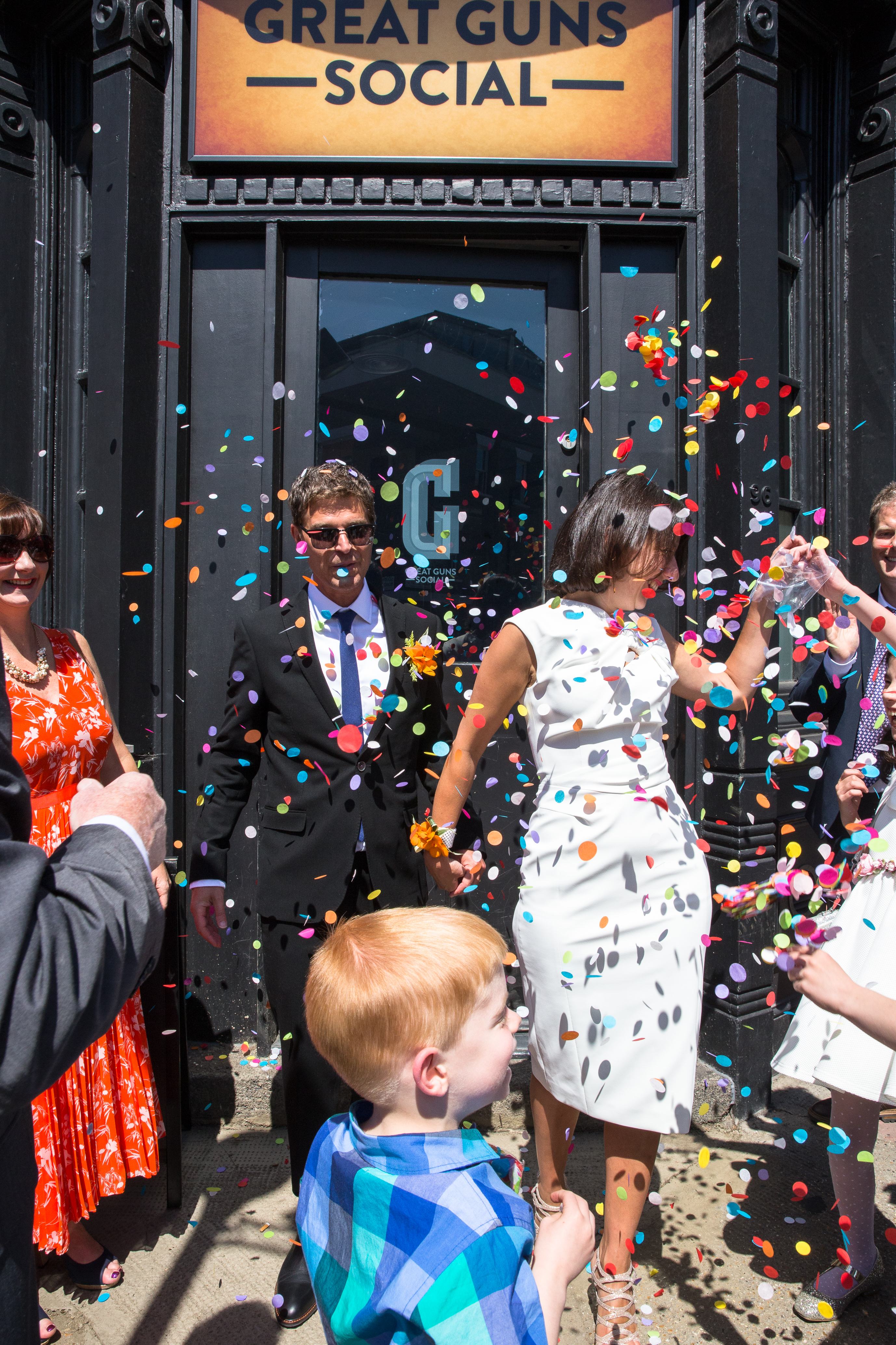 Wedding celebration in Great Guns Social with joyful couple and colorful confetti.