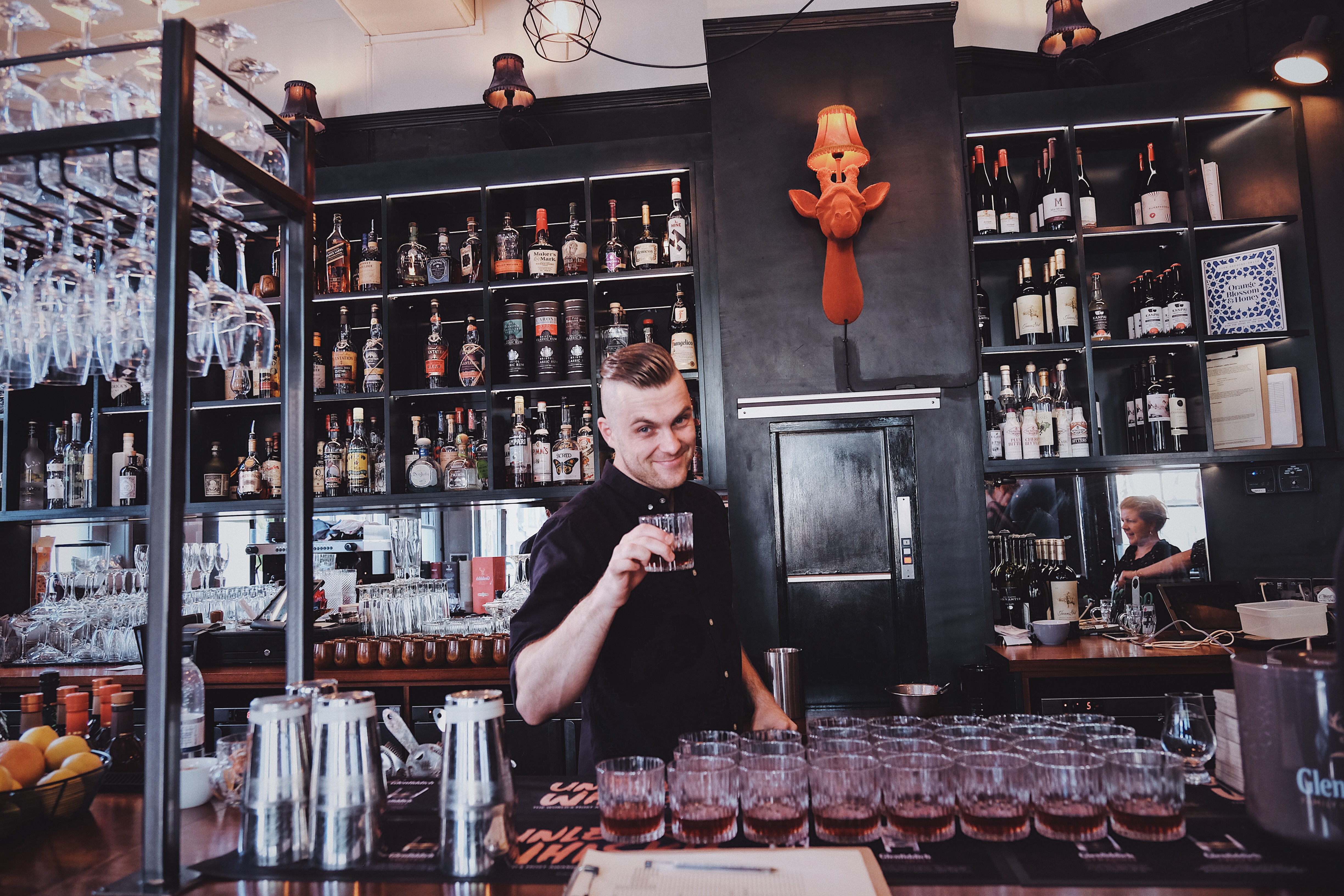 Main Room at Great Guns Social with organized bar, ideal for events and meetings.