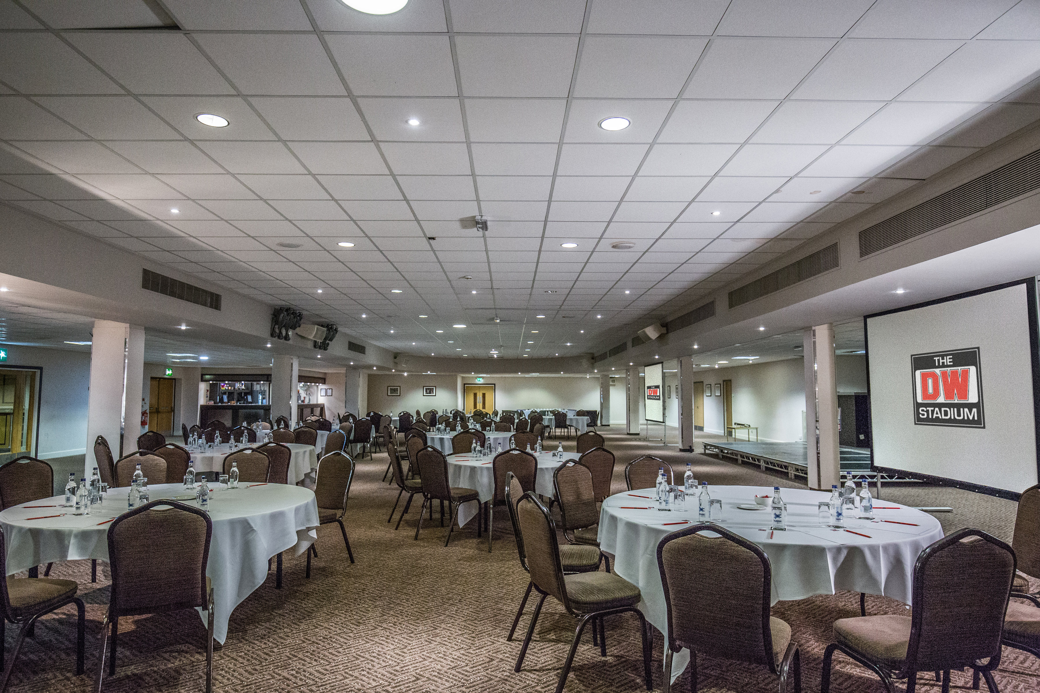 DW Sports Fitness Lounge event space with round tables, ideal for conferences and meetings.