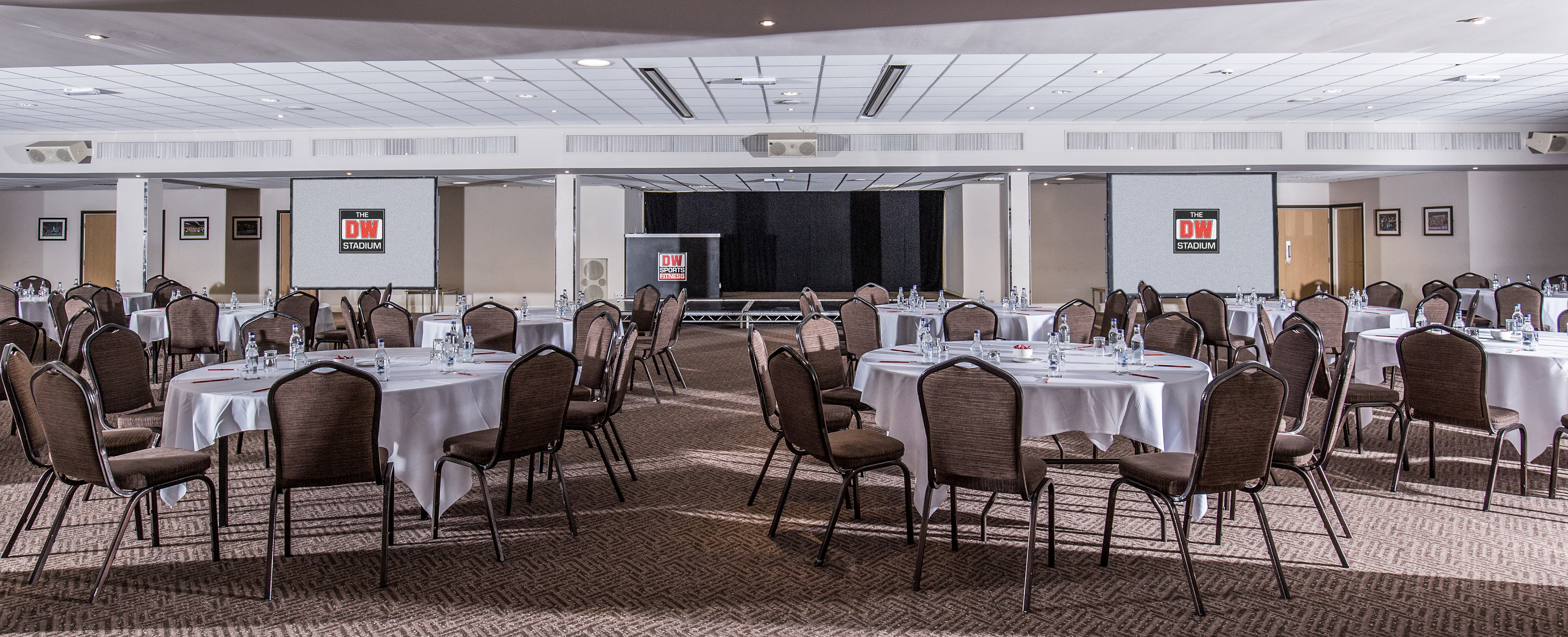 DW Sports Fitness Lounge event space with round tables, ideal for meetings and banquets.