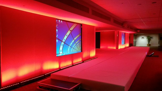 DW Sports Fitness Lounge event space with sleek stage and vibrant red lighting.