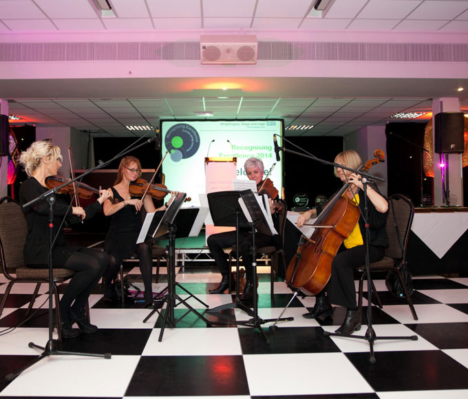 String quartet performing at DW Sports Fitness Lounge, elegant event with checkered floor.