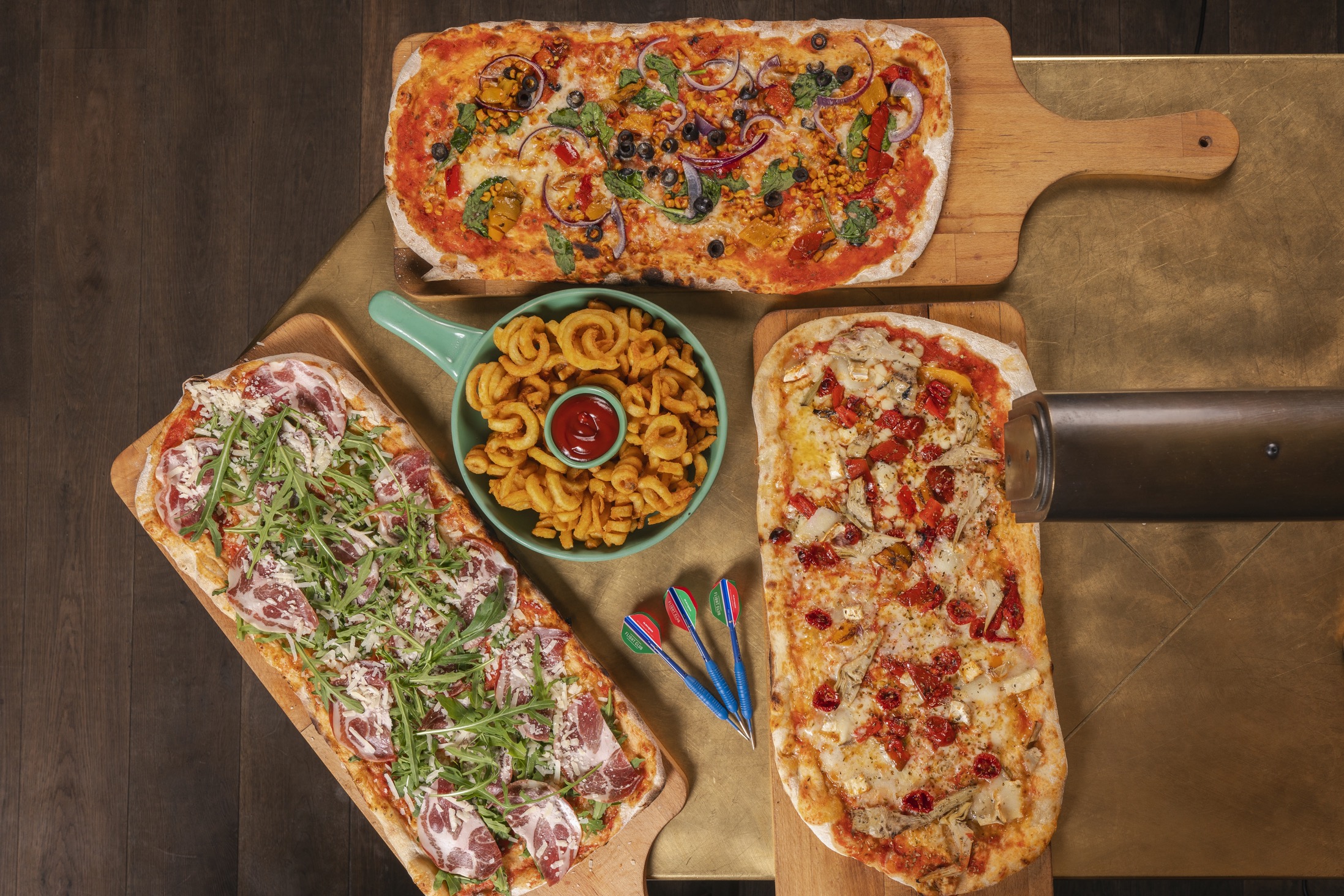 Vibrant pizza spread on wooden boards for casual meetings at Flight Club Victoria.