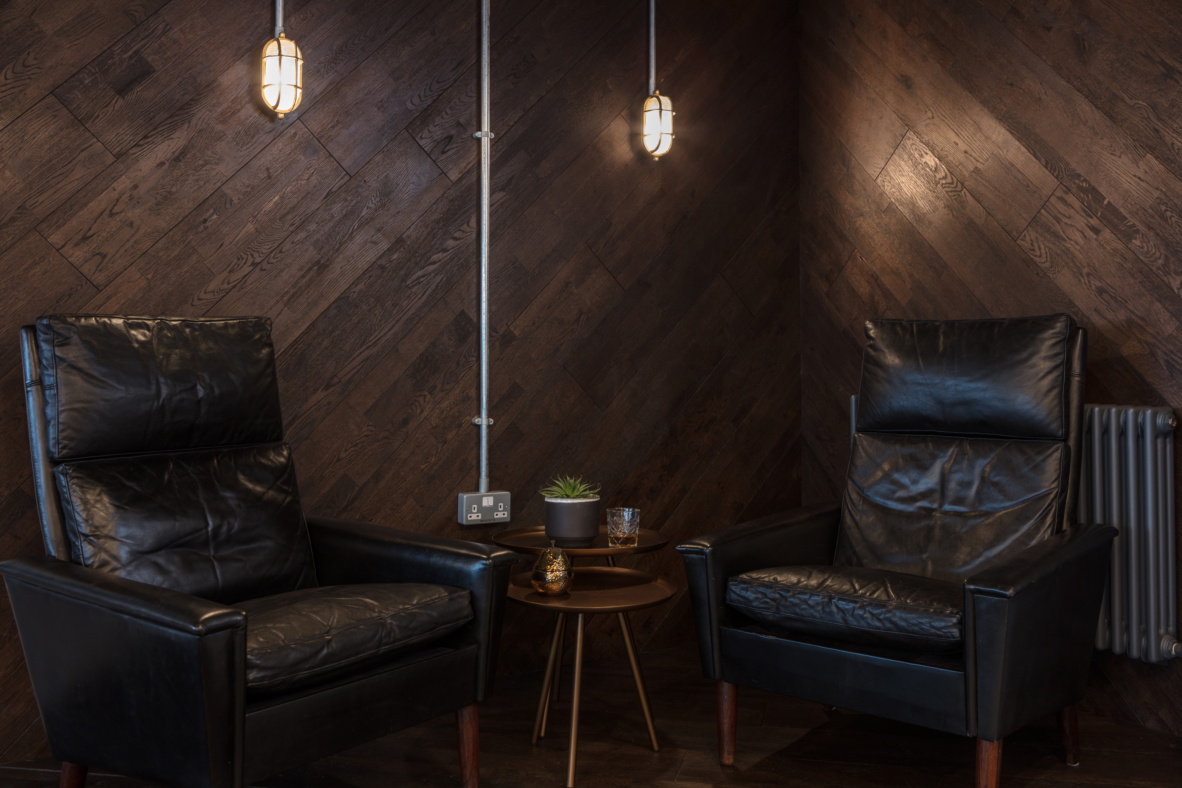 Cozy meeting space with black leather chairs at The Vine Club Brighton for brainstorming sessions.