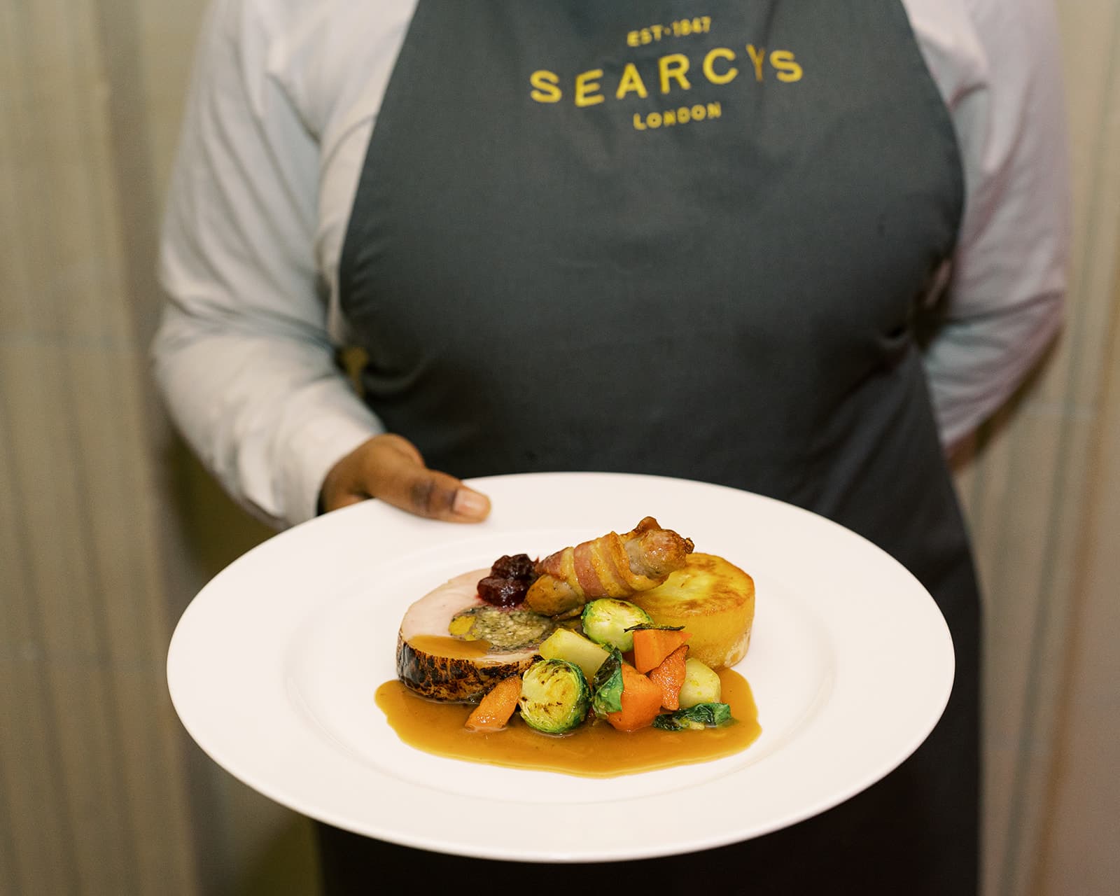 Server presenting gala roast entrée at a Westminster corporate Christmas banquet.