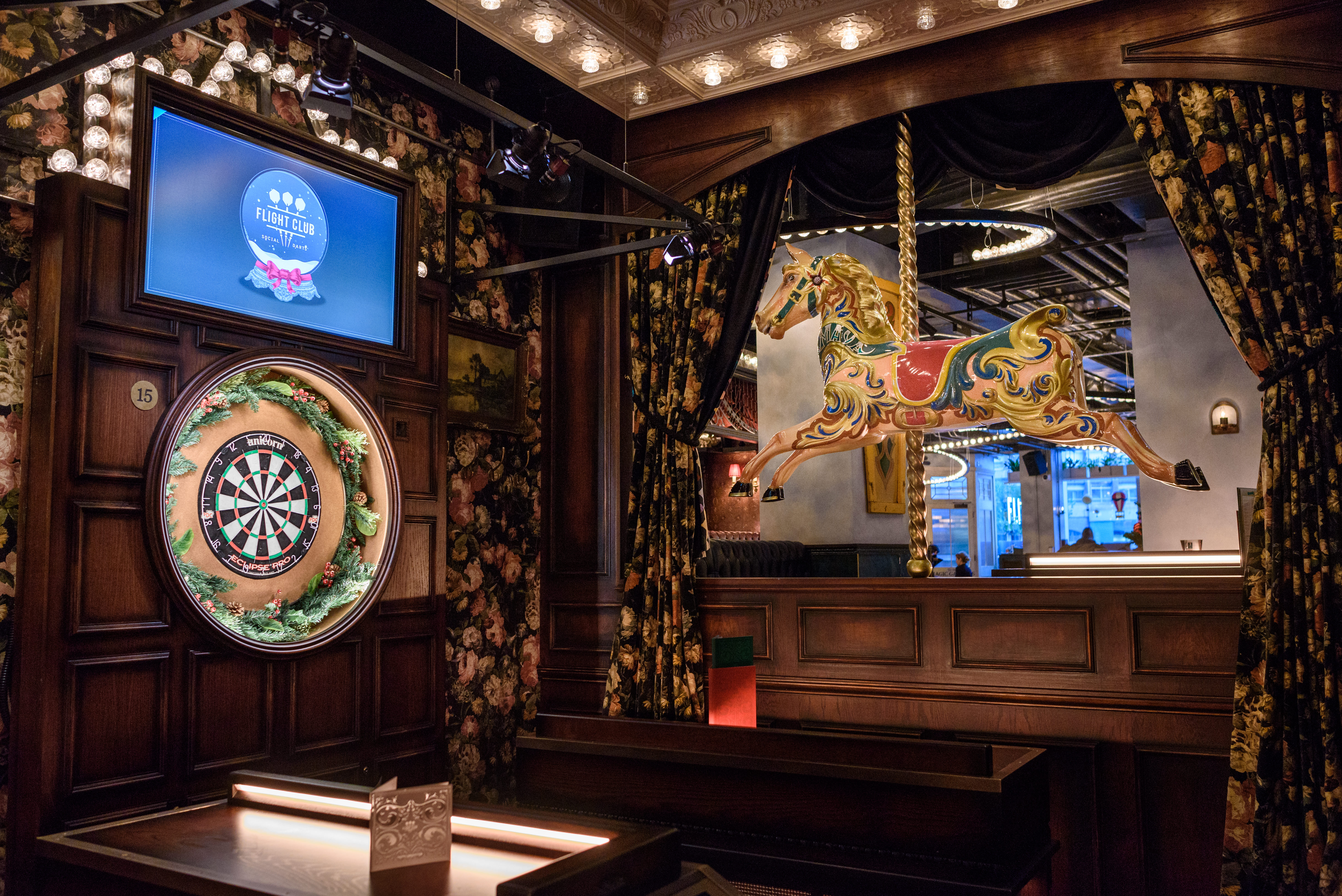 Old Vic event space with dartboard and carousel horse for team-building activities.