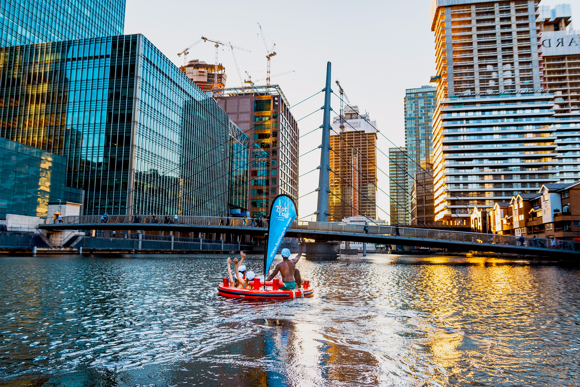 Floating hot tub in urban river setting, perfect for unique team-building events.