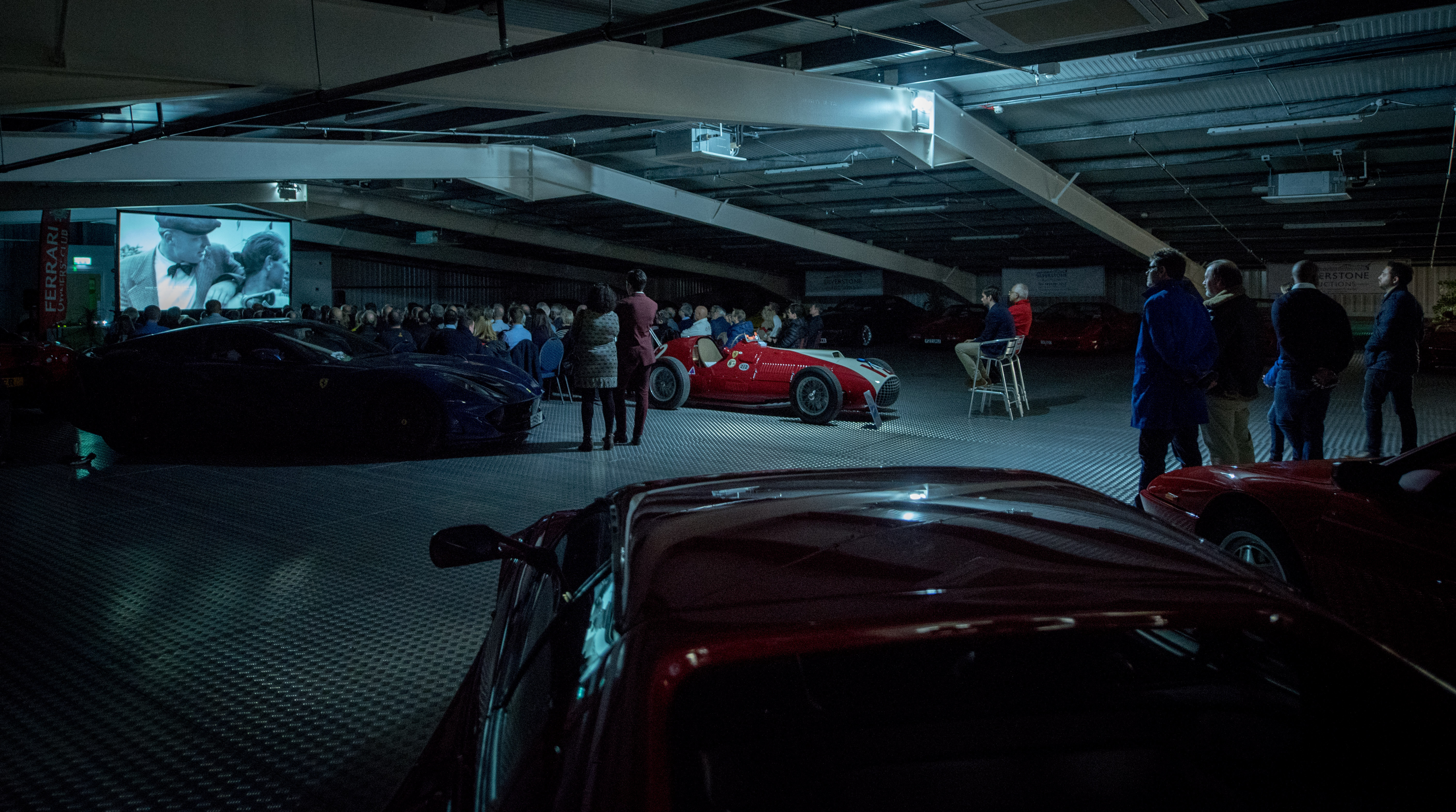 "Intimate event space with luxury cars, ideal for automotive networking and presentations."