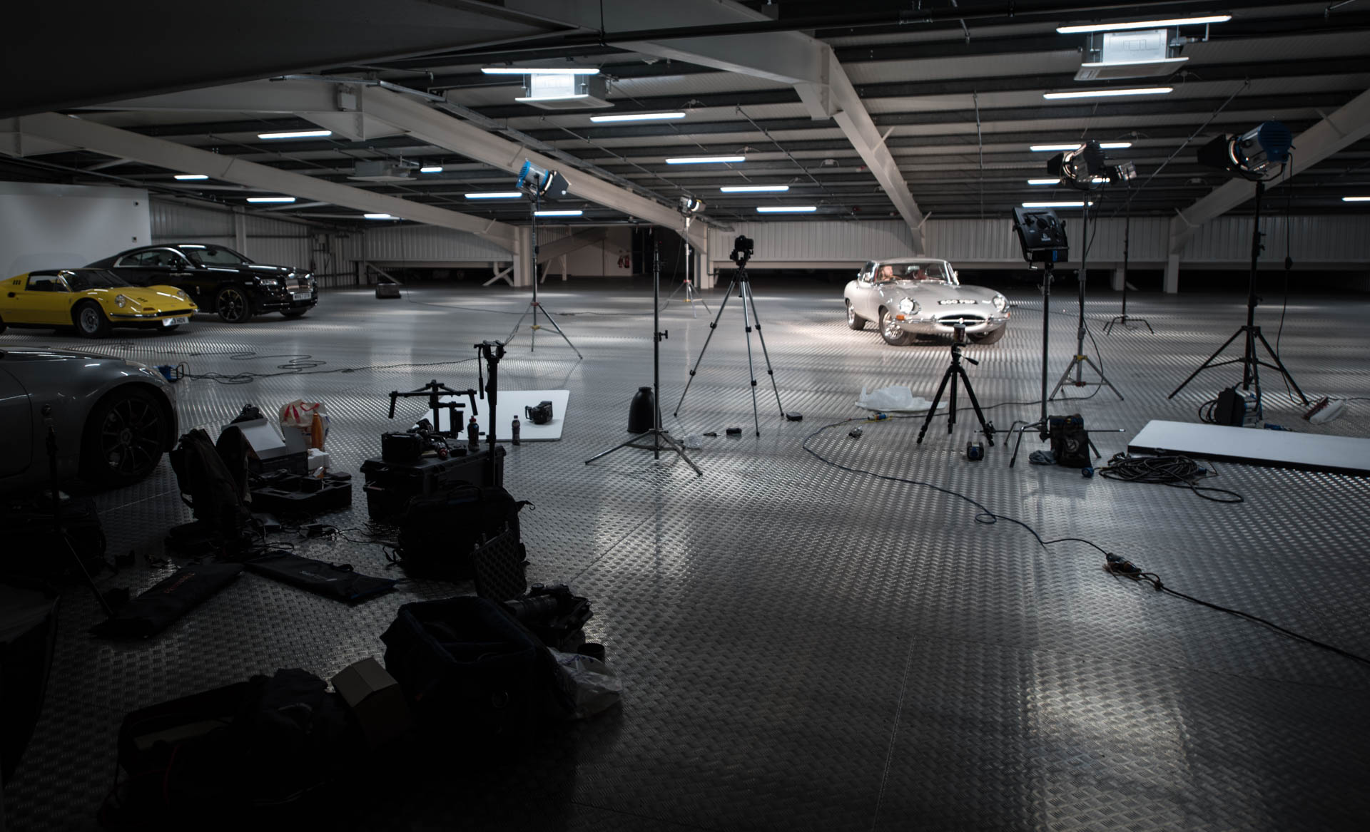 Well-lit automotive studio with sleek cars for product launch or promotional event.