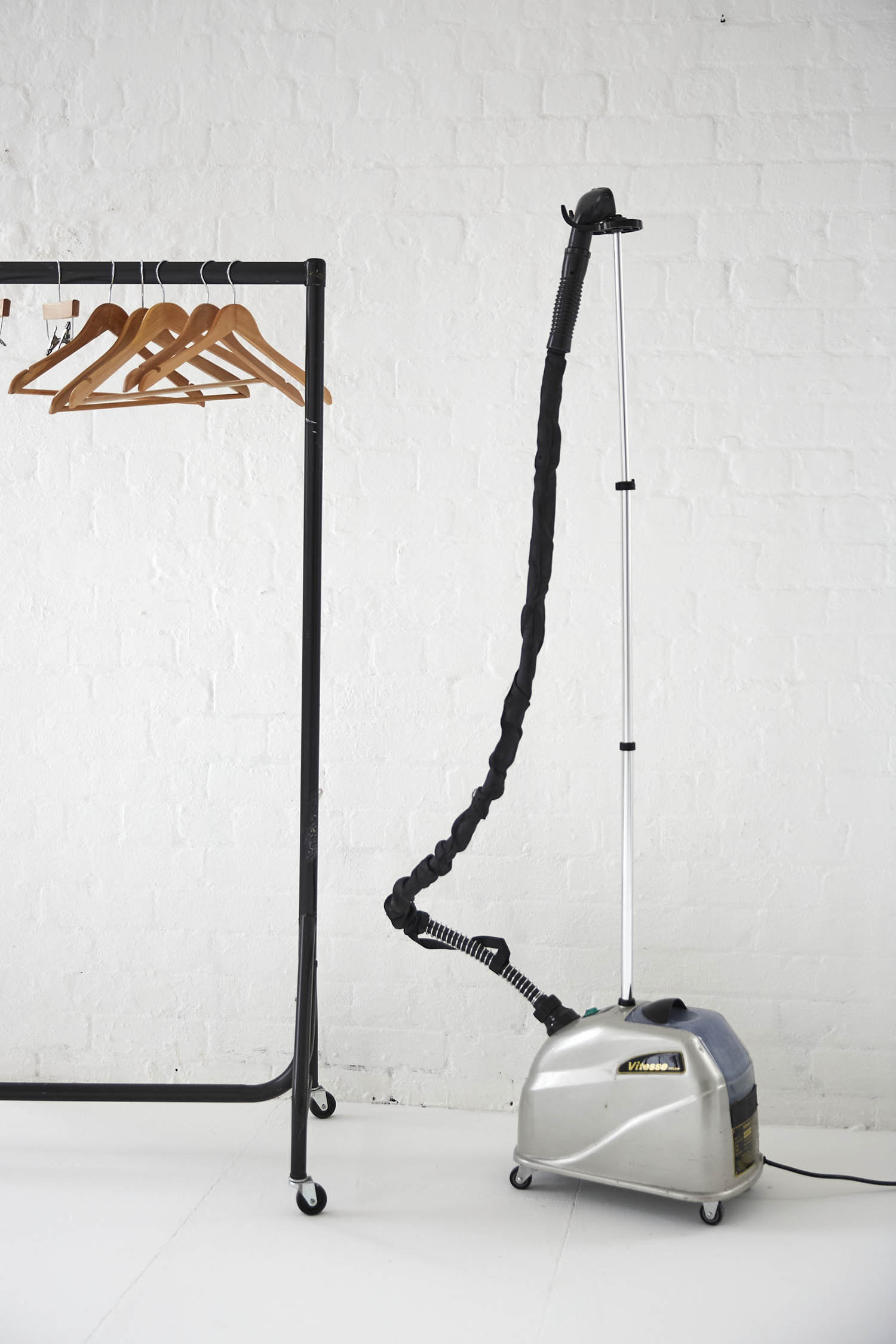 Garment steamer and clothing rack in Tanzaro Studio for professional event preparation.