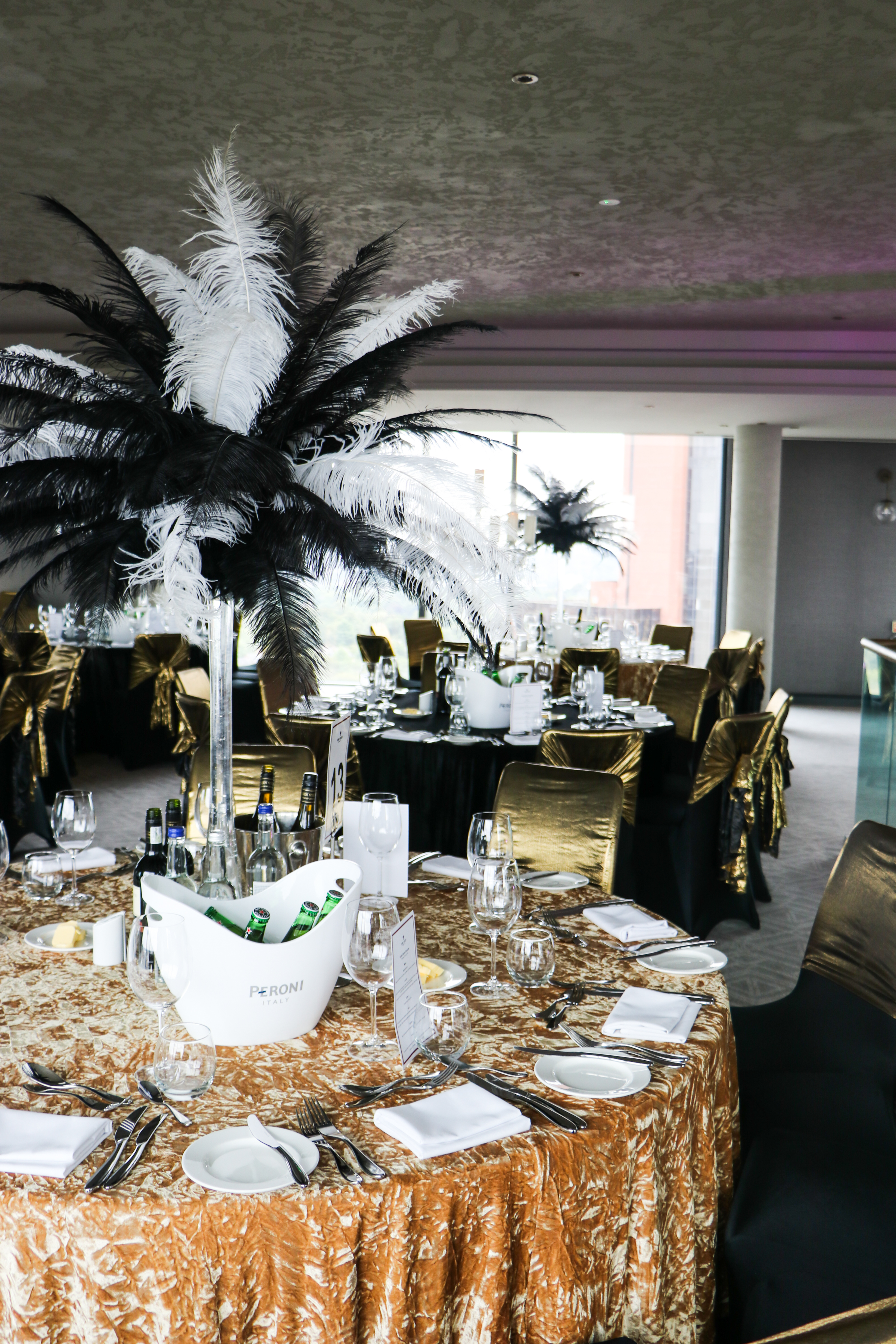 Elegant event space at Sky Gallery, Park Regis Birmingham with gold decor and feather centerpieces.