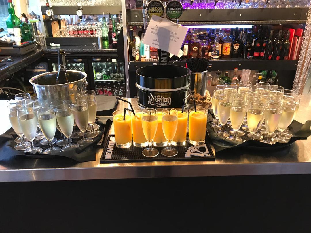 Elegant beverage station with champagne and mimosas for a celebratory event.