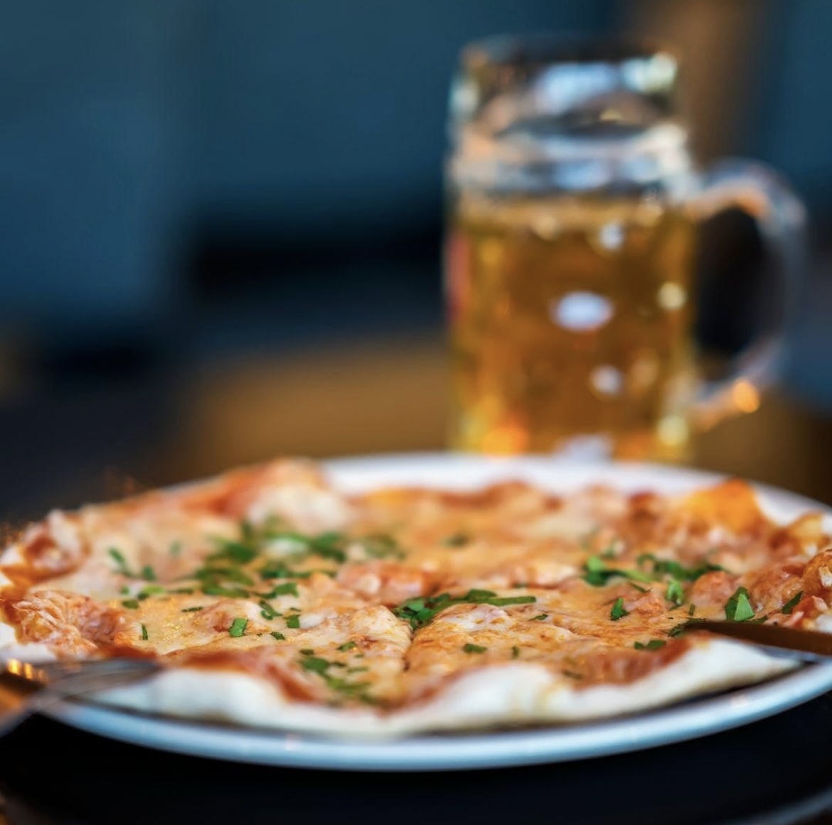 Delicious pizza with herbs and beer at HUCKSTER London for events and networking.