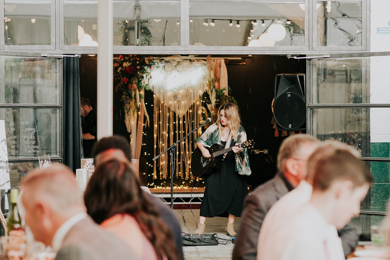 Musician performing on stage at vibrant Peckham Springs event for celebrations and networking.