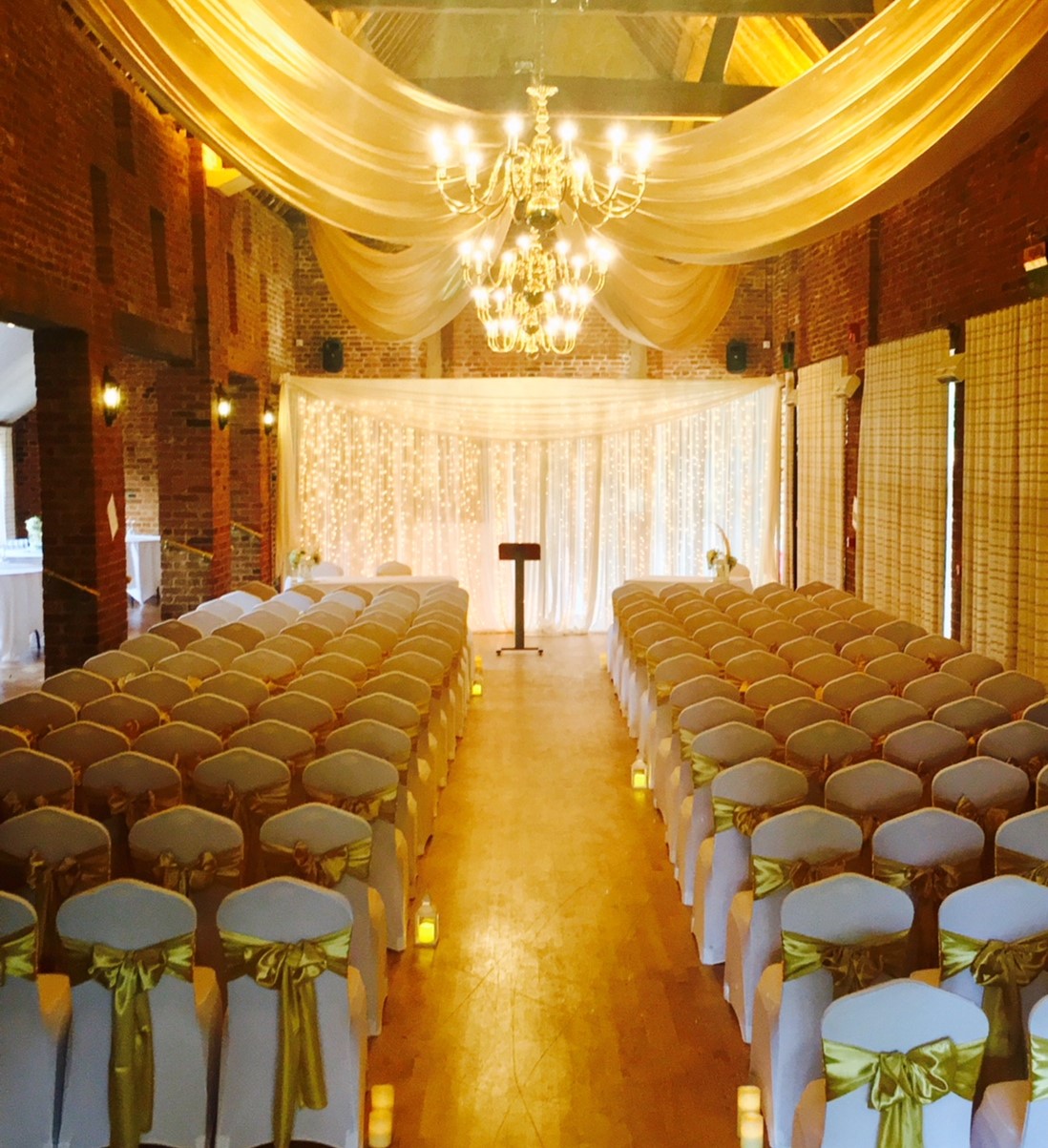 Elegant wedding venue with draped chairs and romantic lighting at The Coach House.