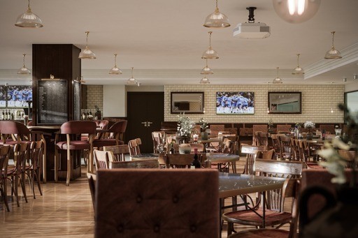 Garisson Suite at Birmingham City FC: stylish event space with wooden tables for gatherings.