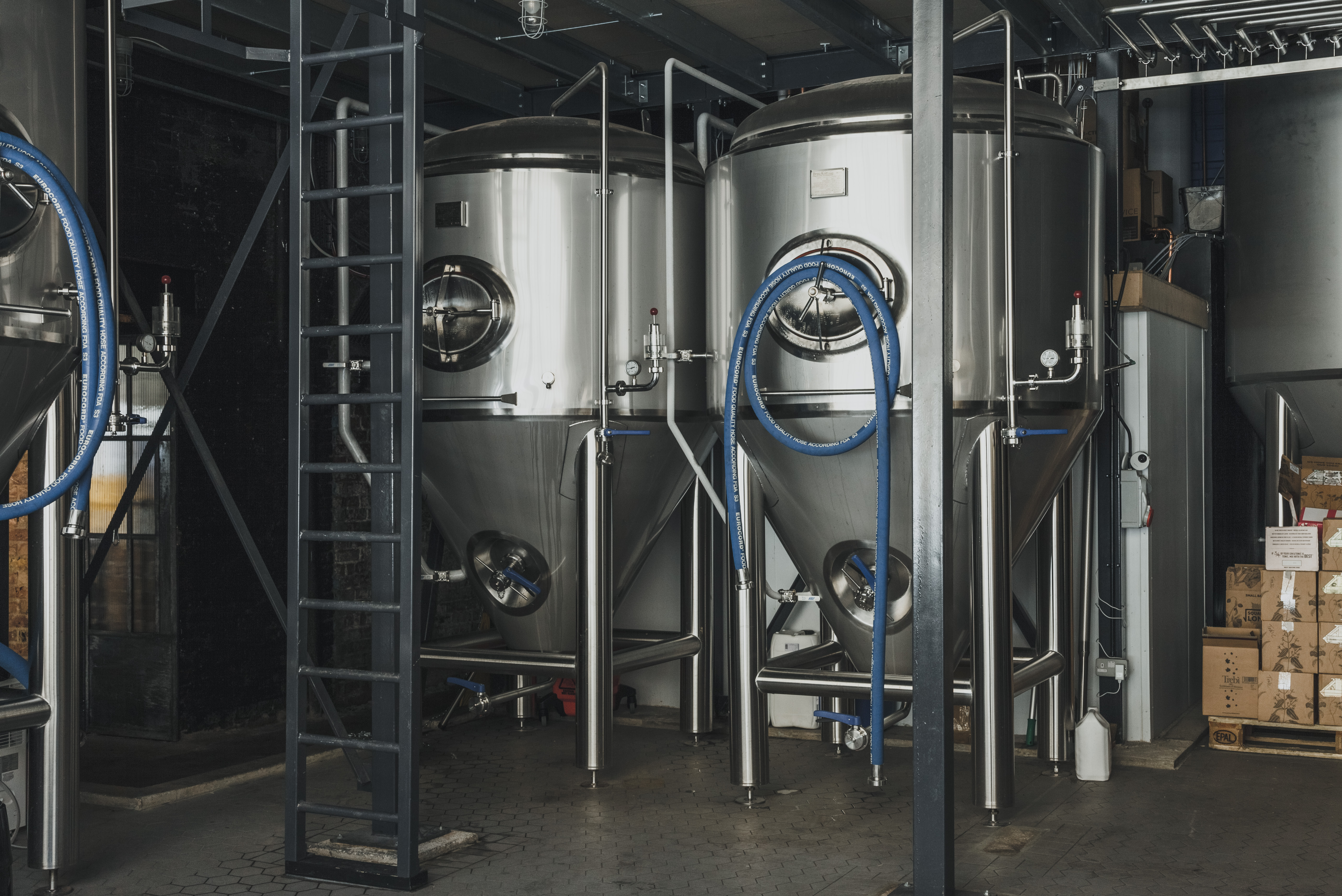 Modern brewery venue with stainless steel tanks for craft beer tastings and corporate events.