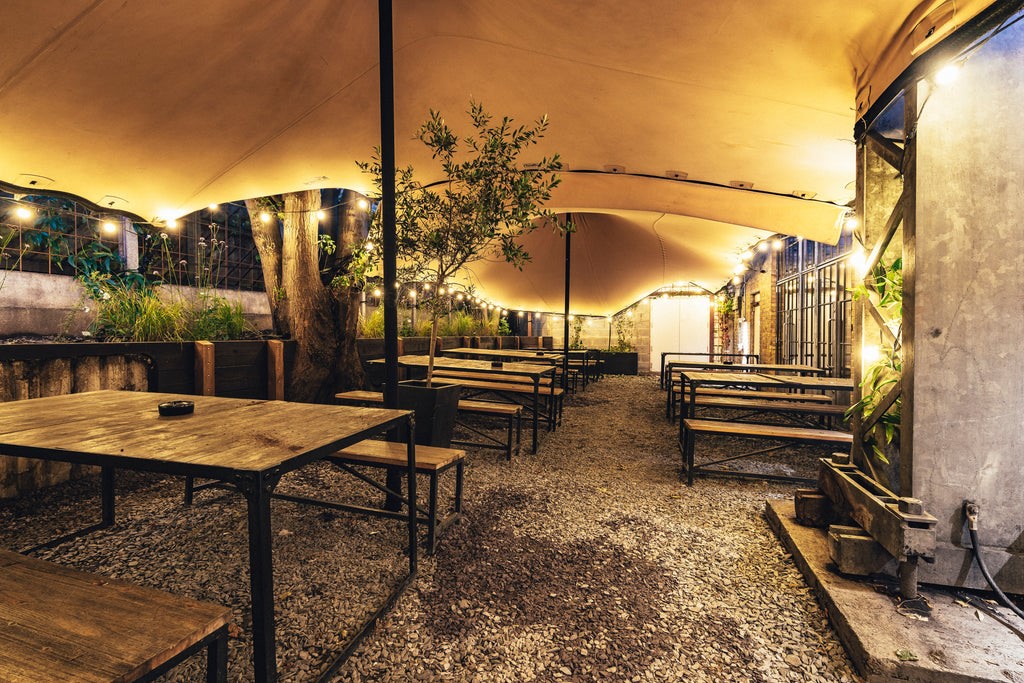 Outdoor event space at Hackney Church Brew Co. with rustic tables and string lights.