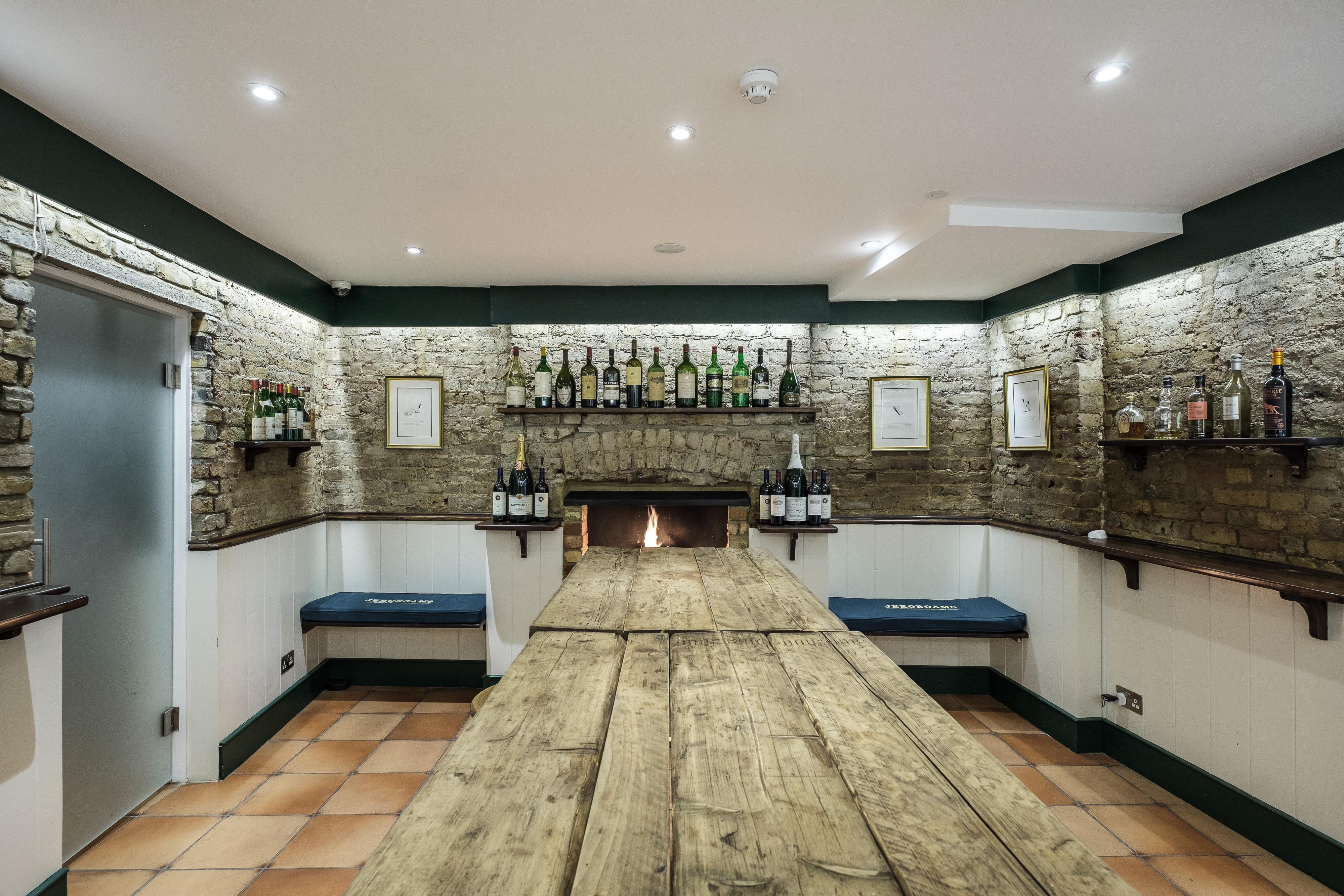 Cozy meeting space in Jeroboams Walton Cellar with rustic table, ideal for gatherings.