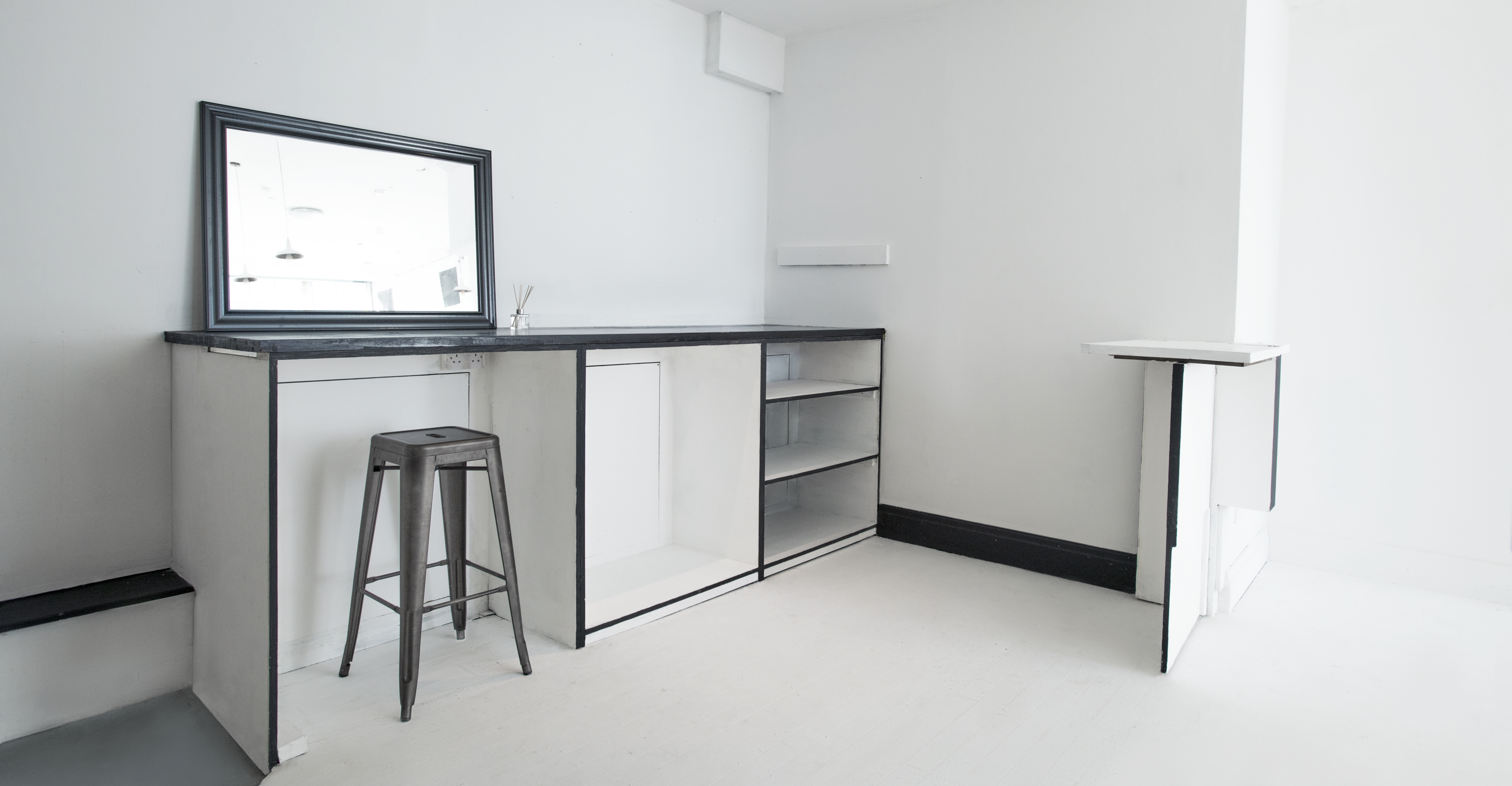 Minimalist event space with sleek bar, ideal for networking and cocktail receptions.