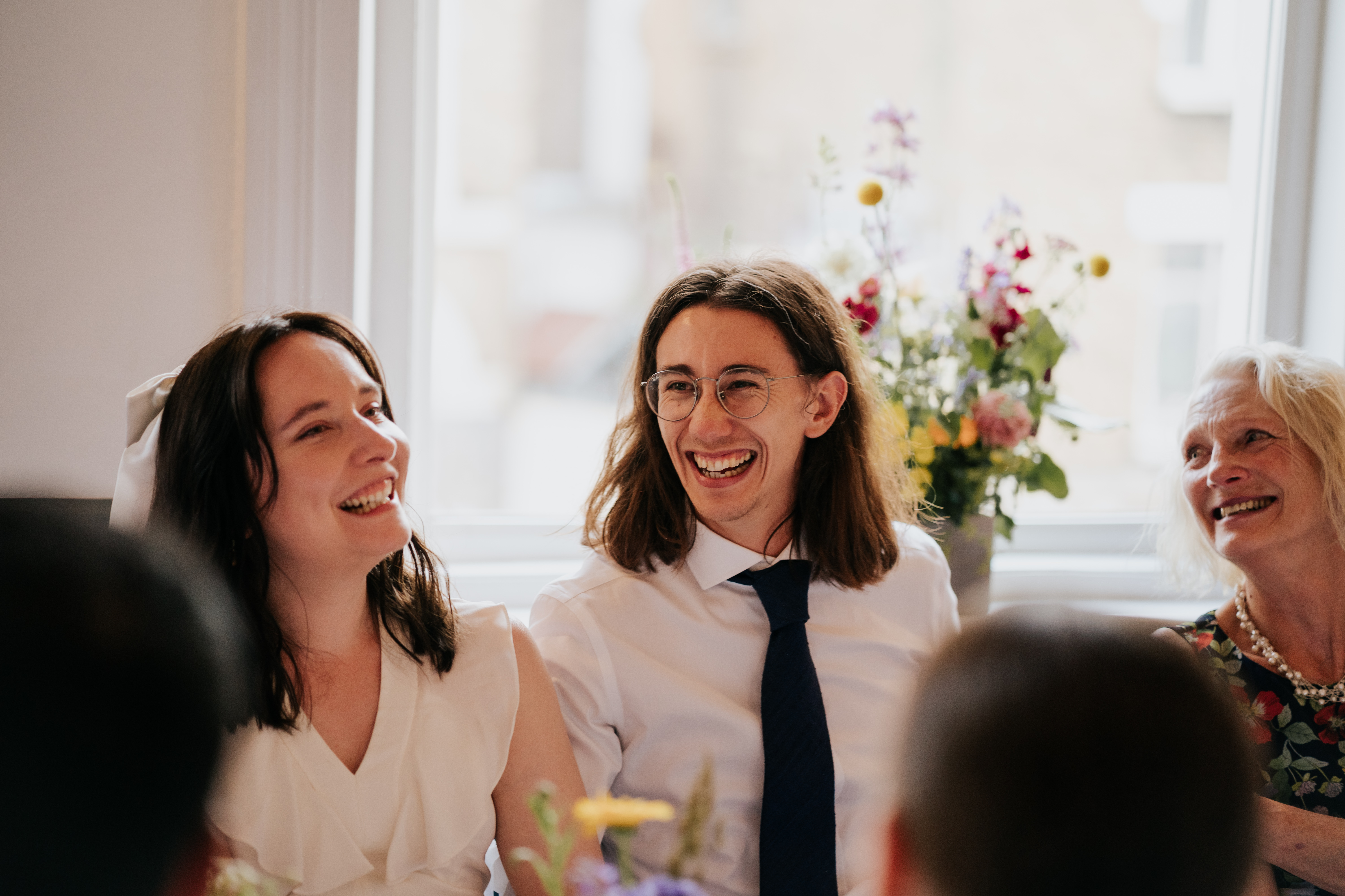Joyful wedding gathering in The Upstairs Room, featuring natural light and floral decor.