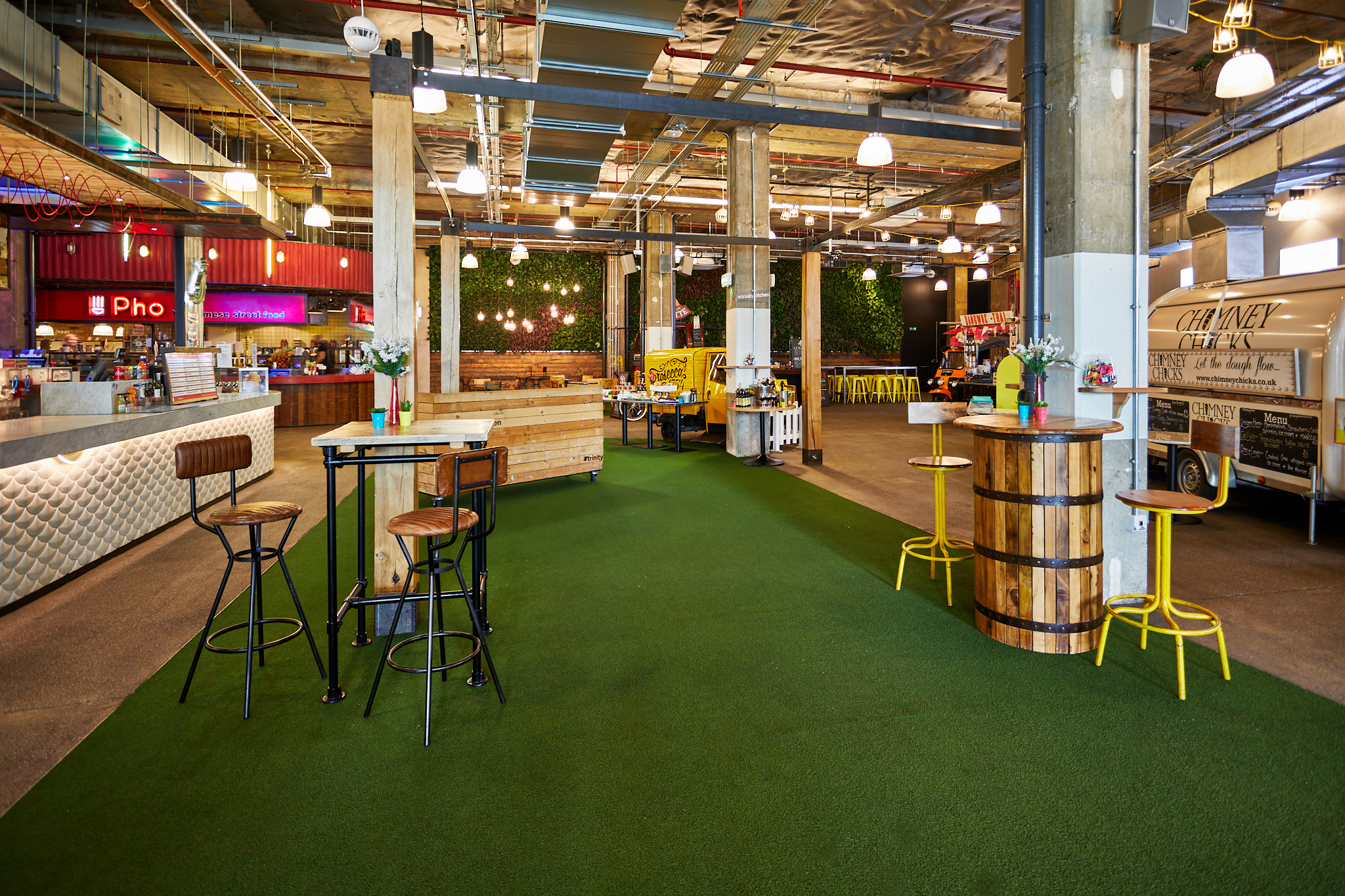 Vibrant event space in Trinity Kitchen with greenery, perfect for casual gatherings and networking.