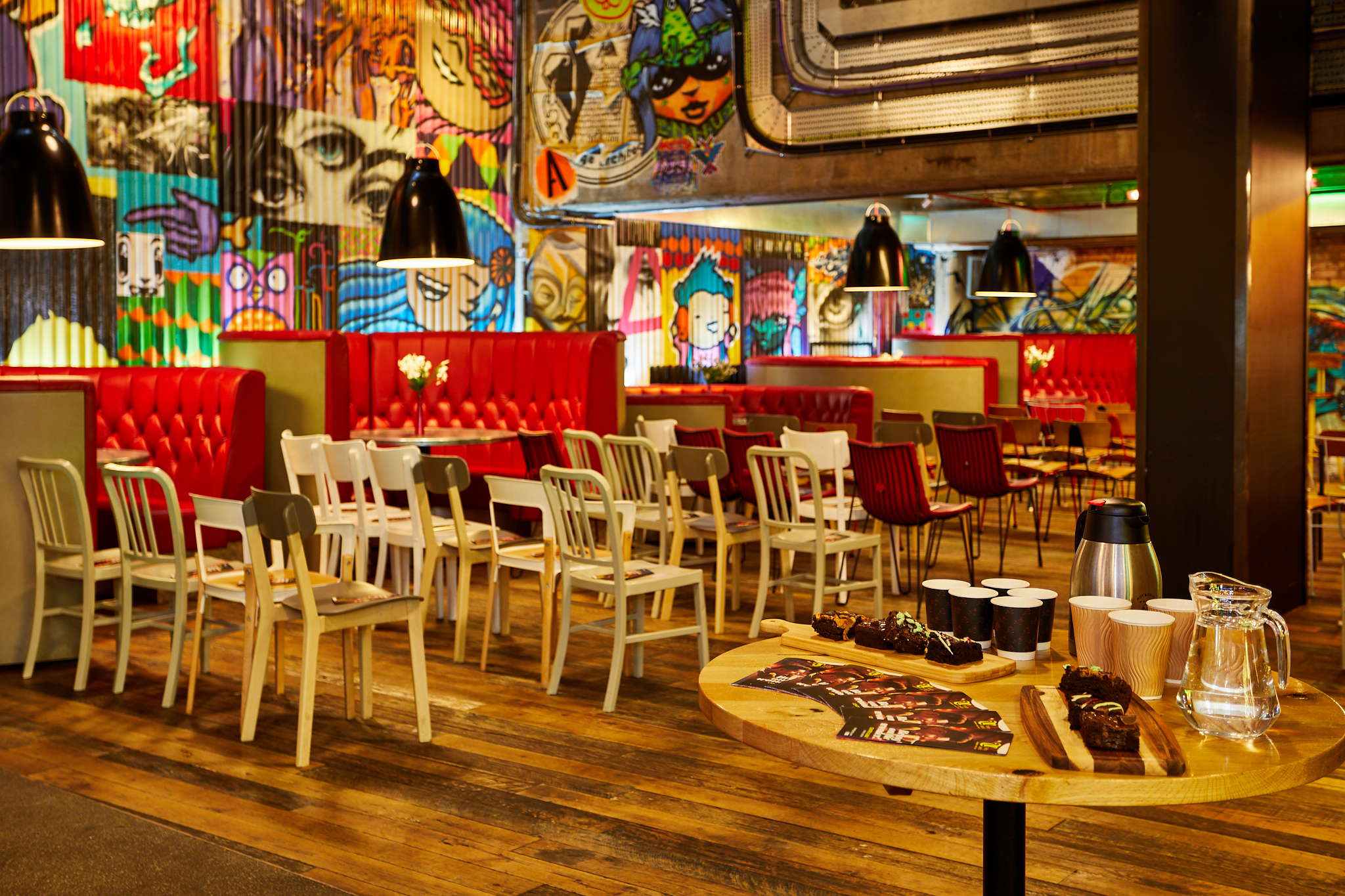 Vibrant Trinity Kitchen event space with bold graffiti art, ideal for gatherings and meetings.