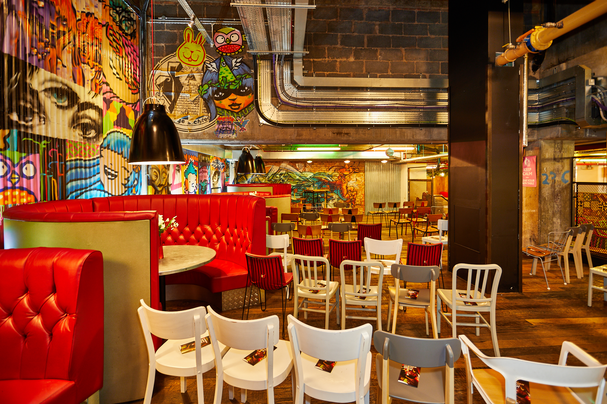 Vibrant urban courtyard with graffiti art, perfect for events and workshops.