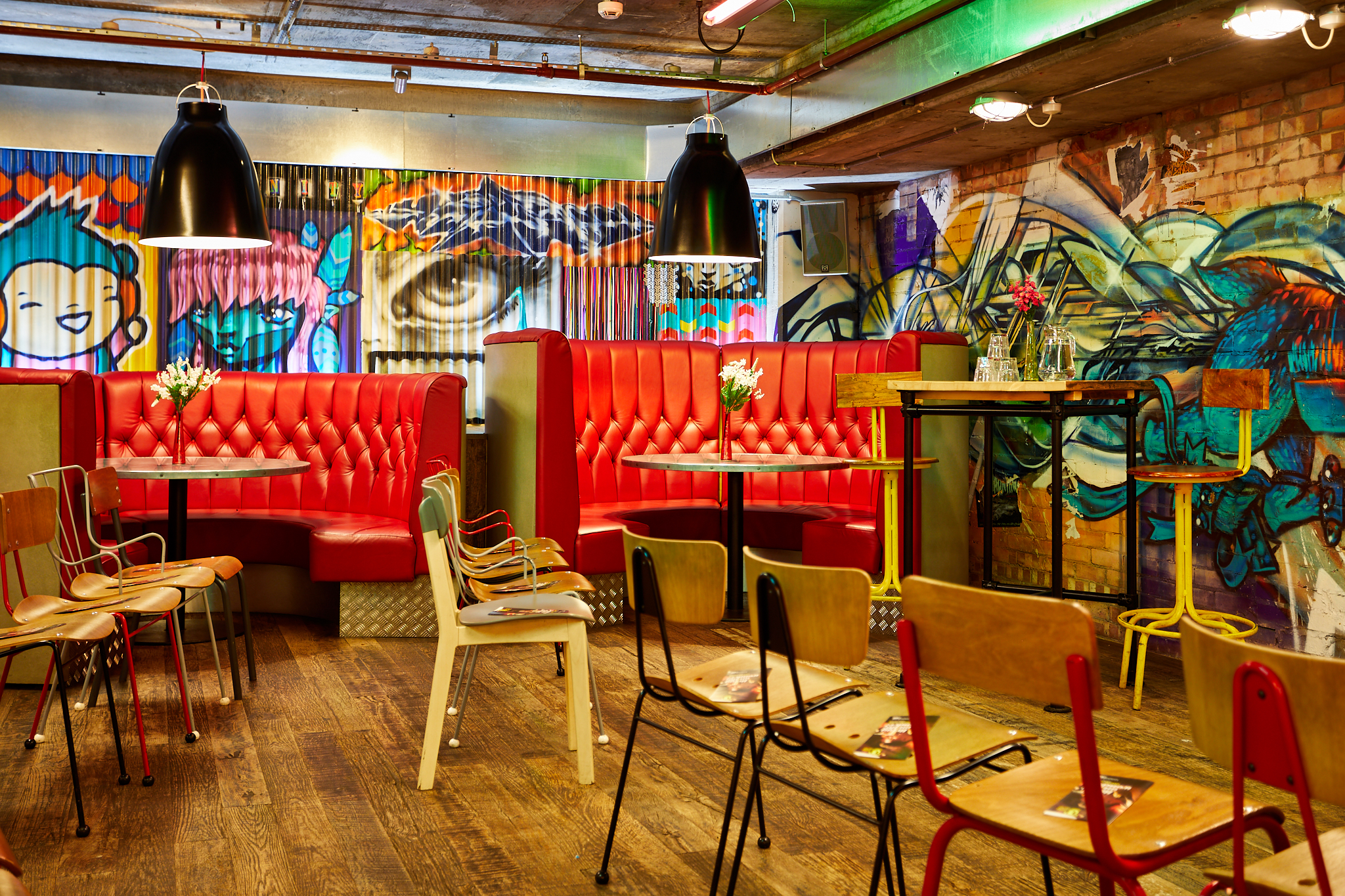 Vibrant urban courtyard with red booths, ideal for networking events and casual meetings.