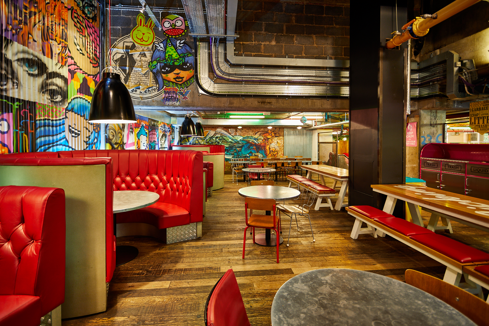 Vibrant urban courtyard with colorful murals, ideal for casual meetings and events.