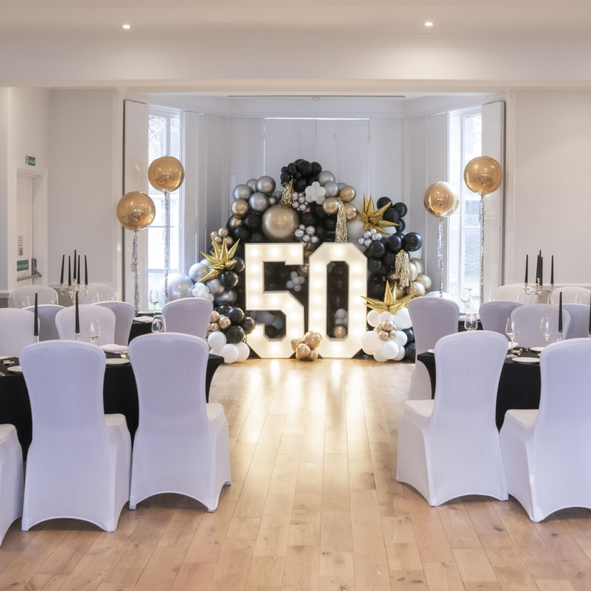 Ballroom at Linden House with elegant 50th birthday setup and striking balloon installation.
