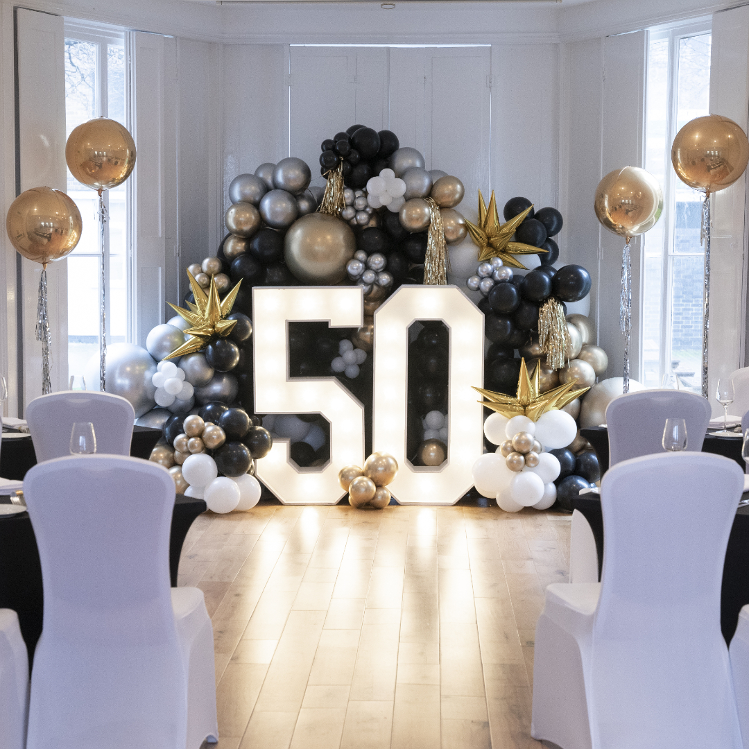 Ballroom at Linden House with elegant black, gold, and white balloon display for 50th birthday.