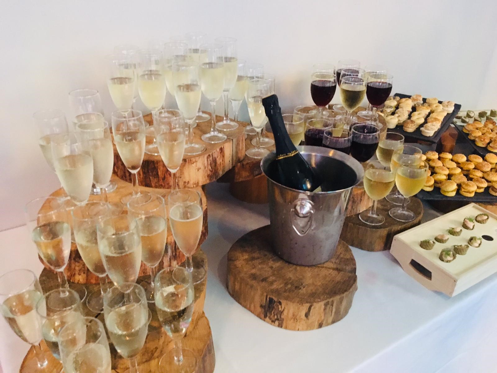 Elegant beverage station with sparkling wine, cupcakes, and chocolates for events.