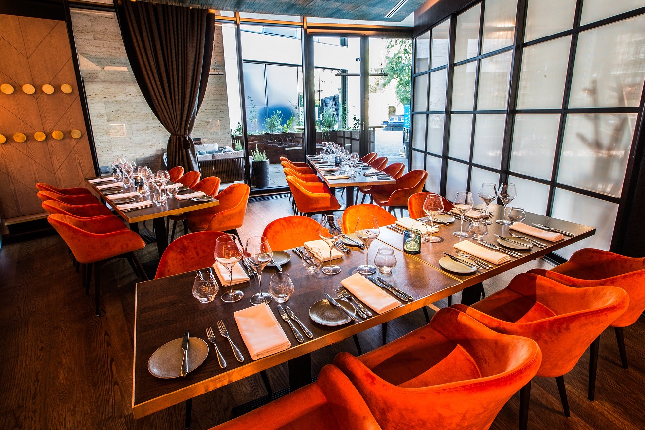 Private dining room with vibrant orange chairs, ideal for corporate events and intimate gatherings.
