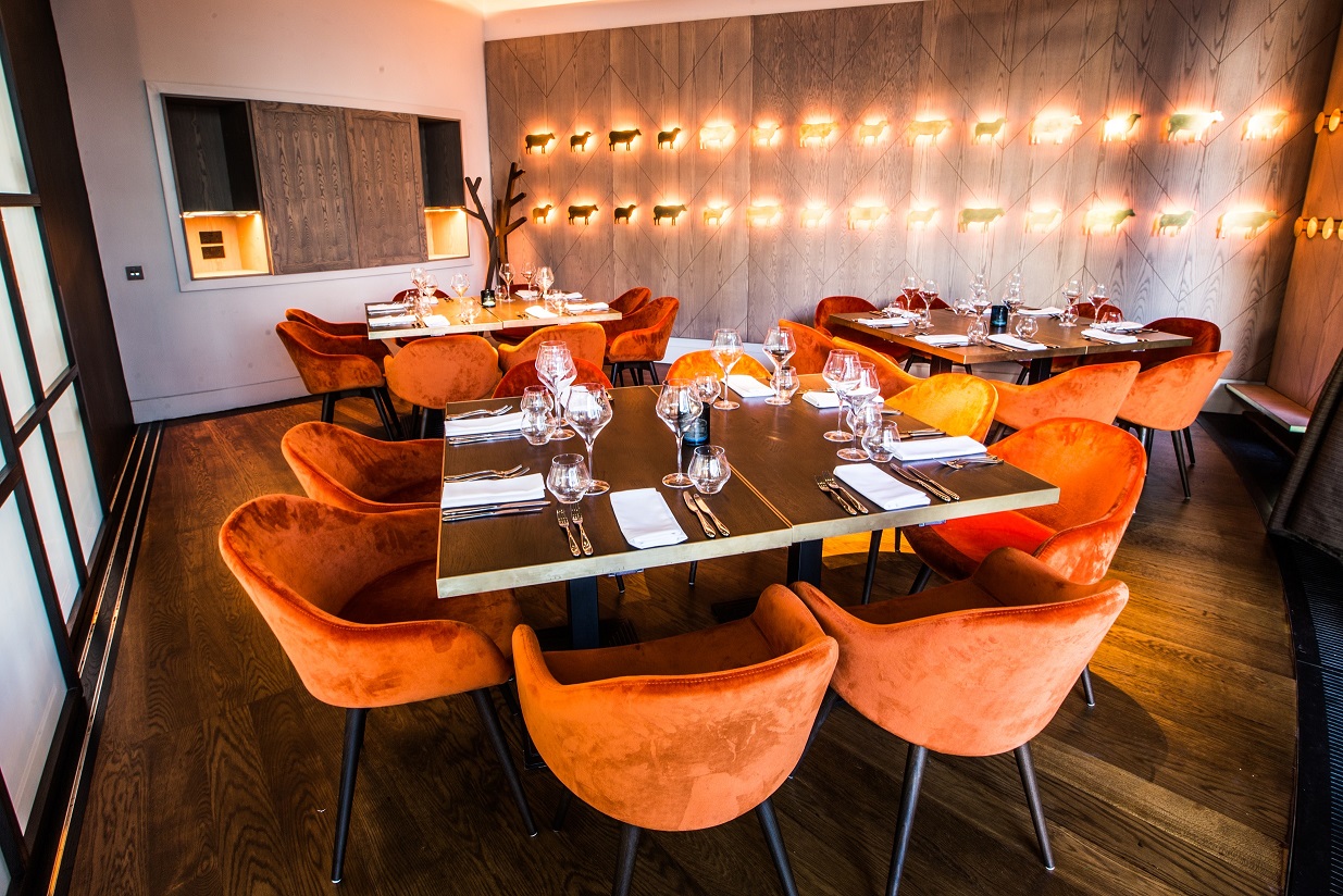 Private dining room with vibrant orange chairs, ideal for intimate gatherings and corporate events.