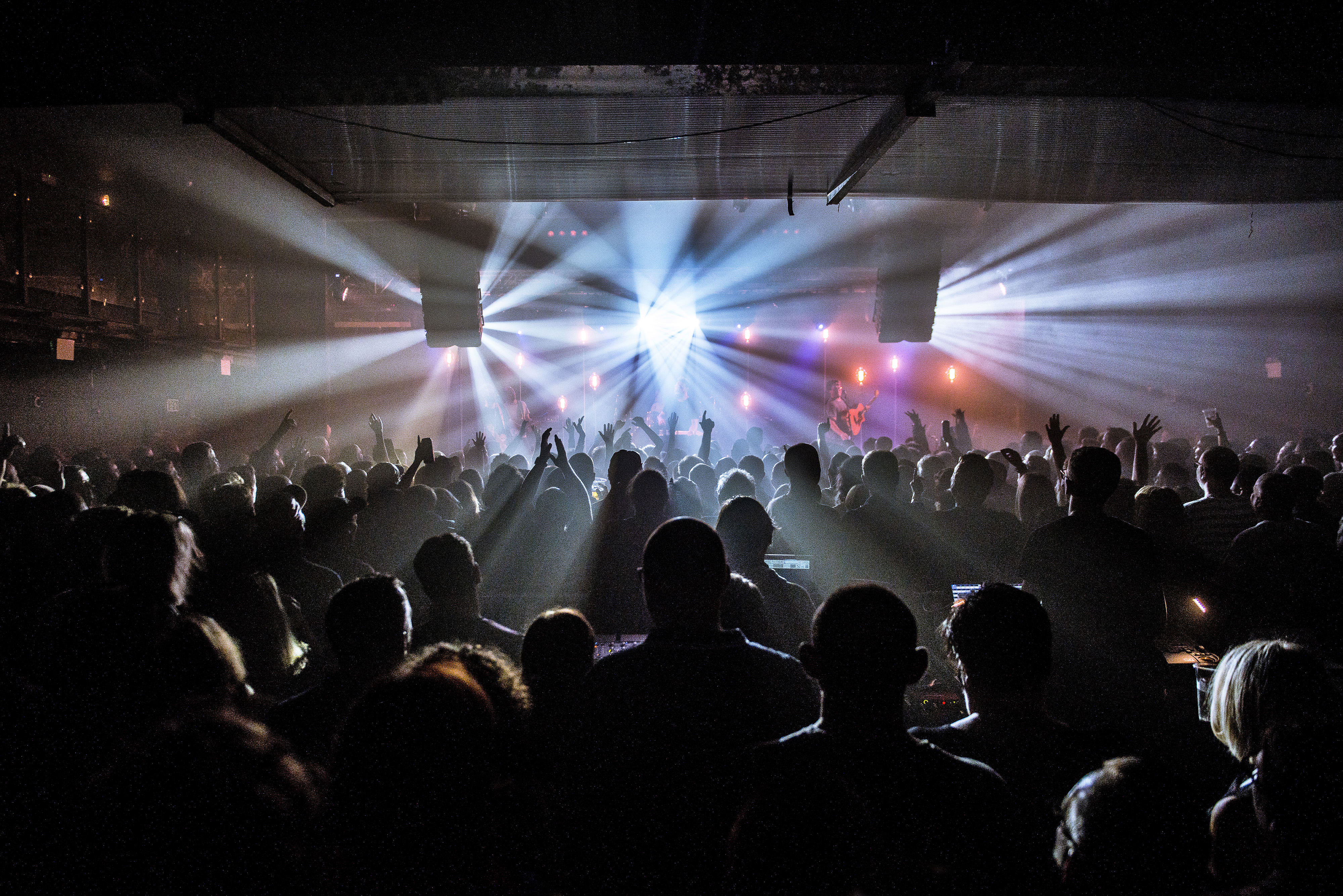Lively concert in XOYO Birmingham's main room with dramatic lighting and packed audience.