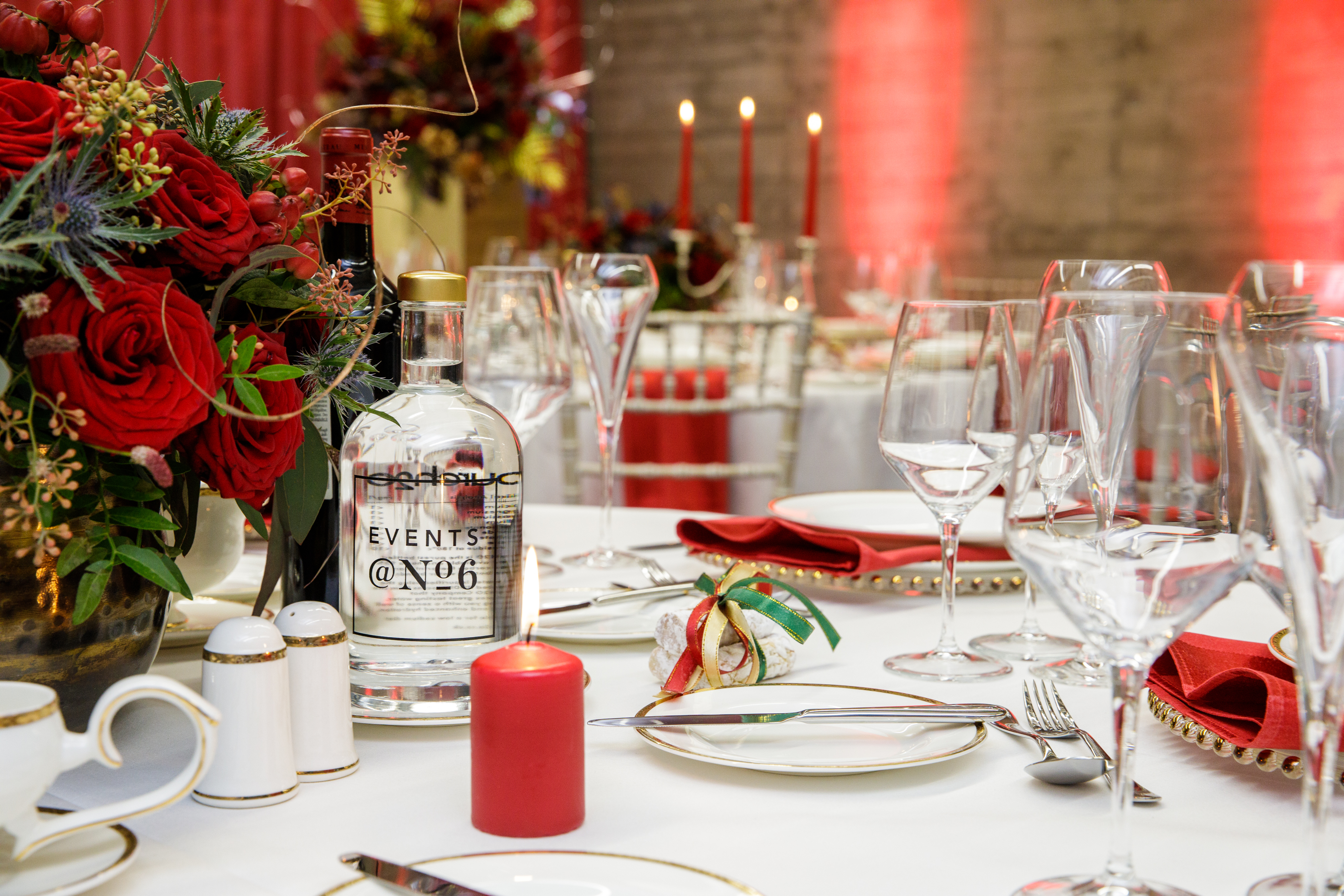 Elegant dining table with red floral centerpiece for sophisticated events at Elizabeth Room.