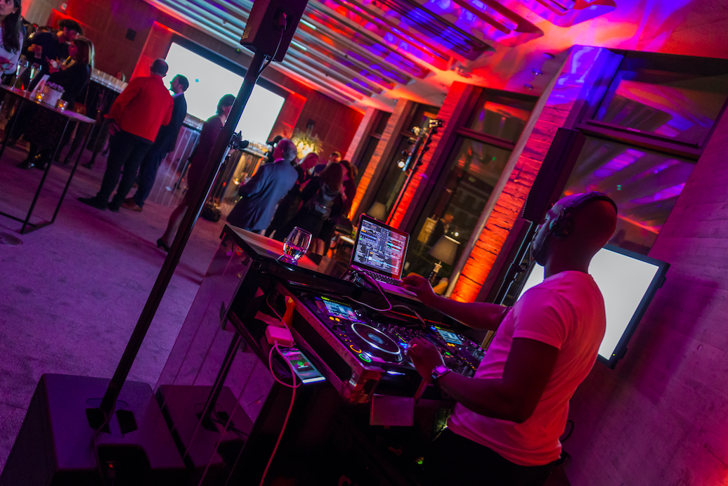 Vibrant event space with DJ, colorful lighting for networking or celebration events.