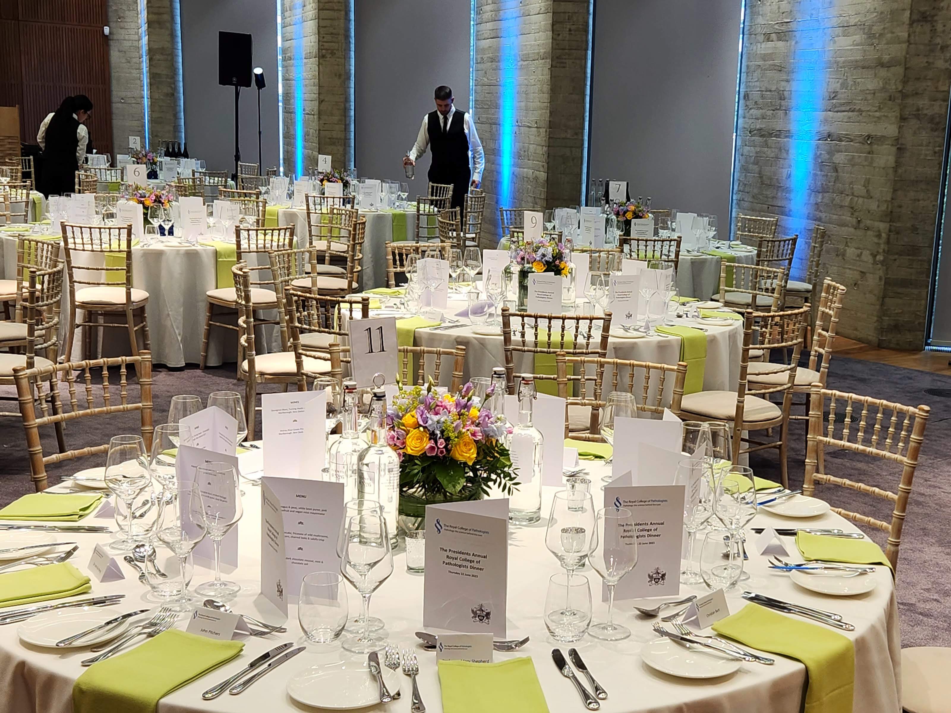 Elegant event space with white linens and floral centerpieces for formal gatherings.