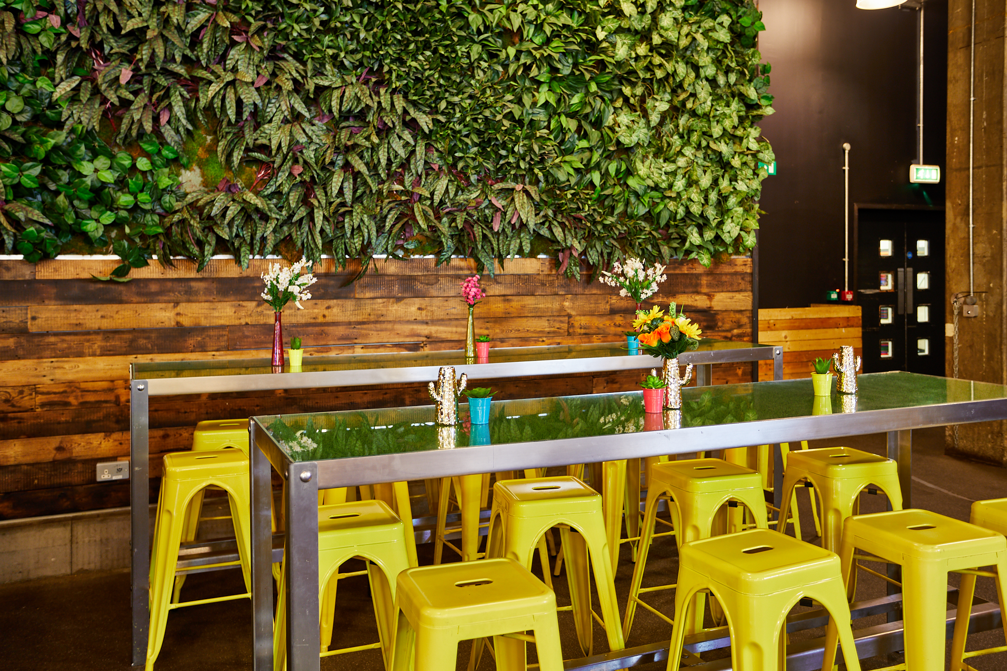 Urban Park event space with lush green wall, ideal for networking and casual meetings.
