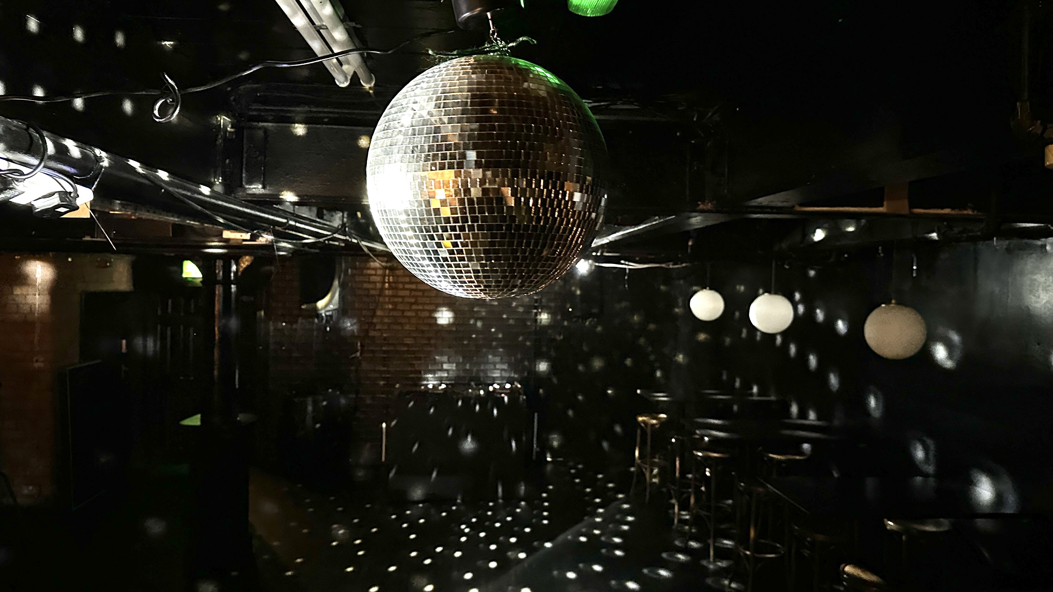 Vibrant event space with disco ball at The Whiskey Jar Basement for social gatherings.