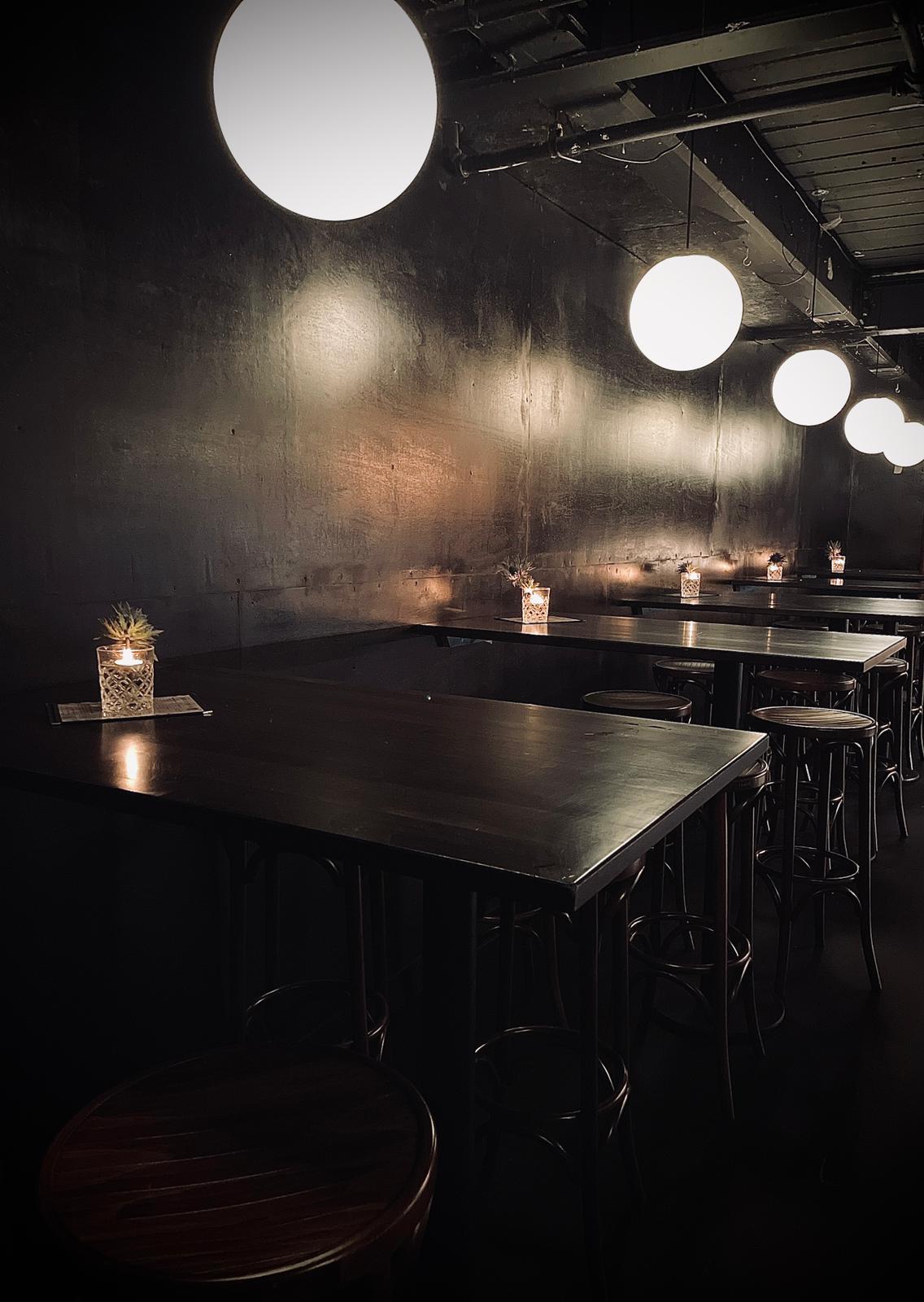 Sleek event space with dark walls, ideal for cocktail receptions and private dinners.