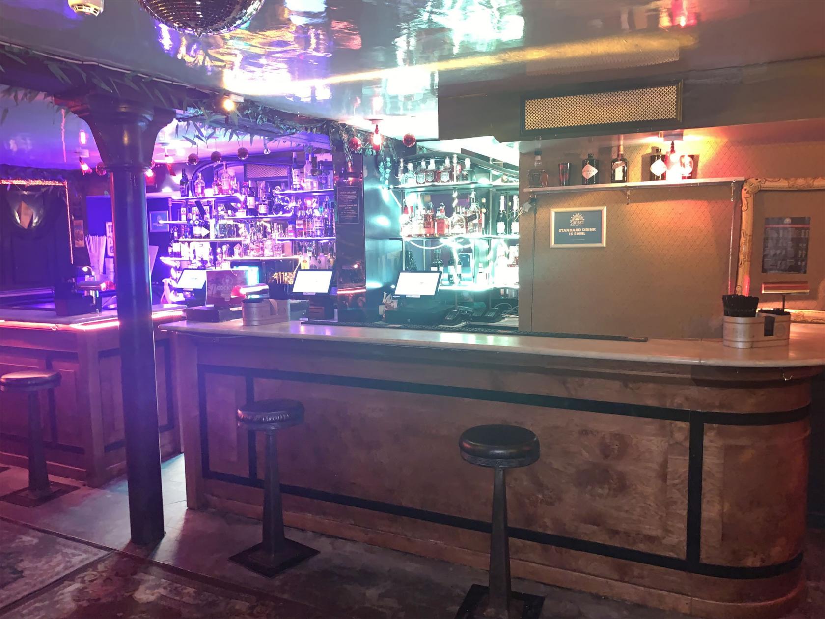 Vibrant Sunset Bar venue with colorful lighting for cocktail receptions and networking events.