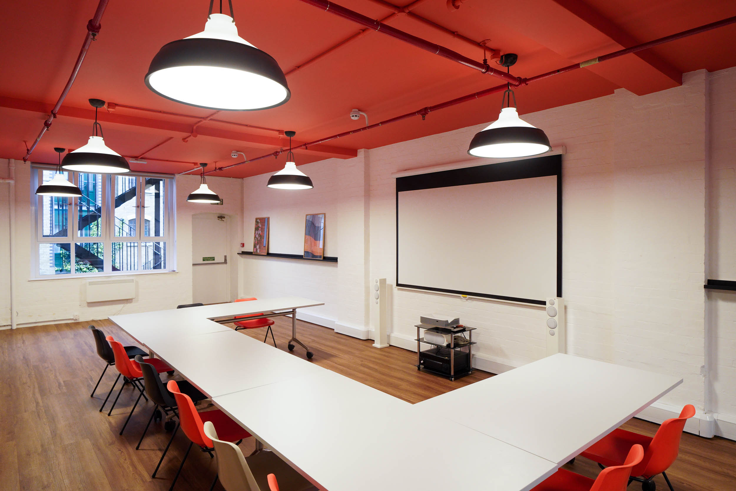 Modern meeting room at The Hive, London Bridge with a vibrant red ceiling for workshops.