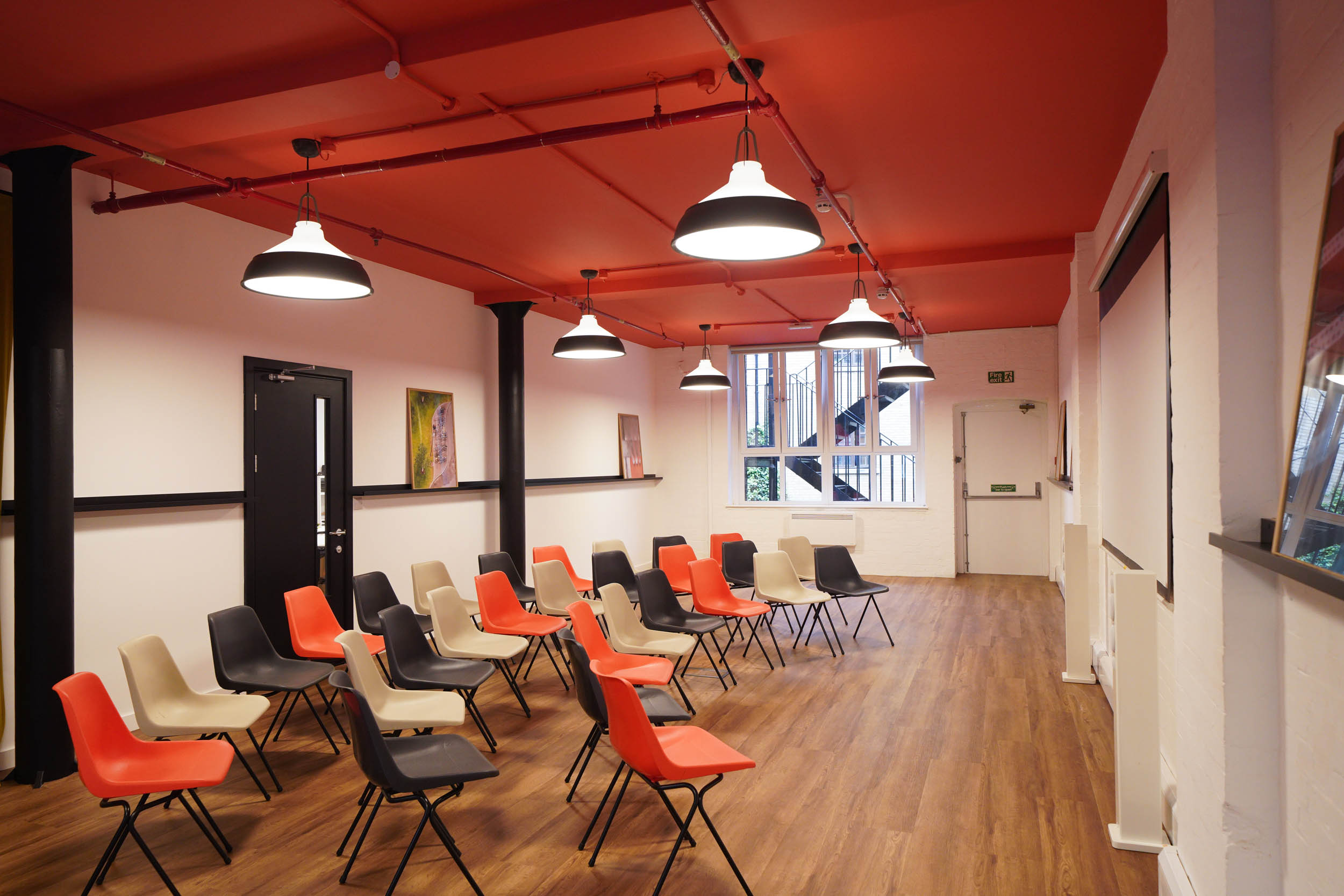 Versatile meeting space at The Hive, London Bridge with colorful chairs for workshops.