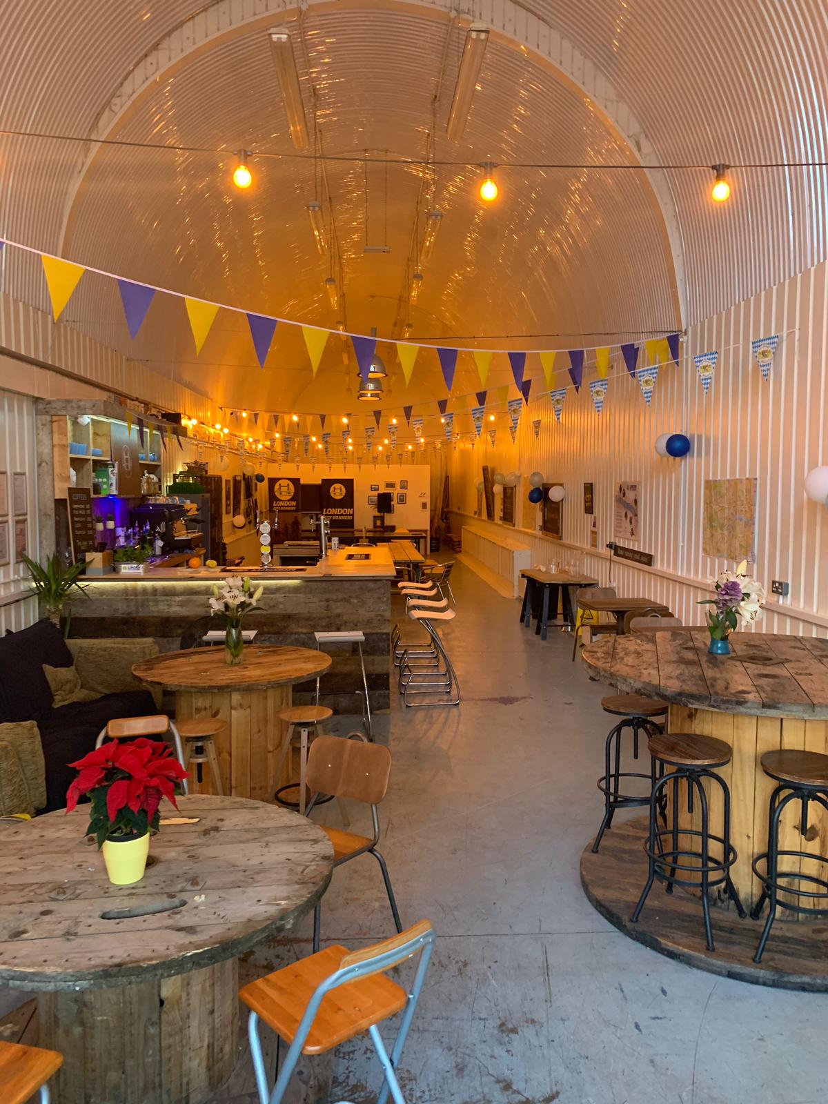 Versatile event space in London with wooden tables, ideal for networking and gatherings.