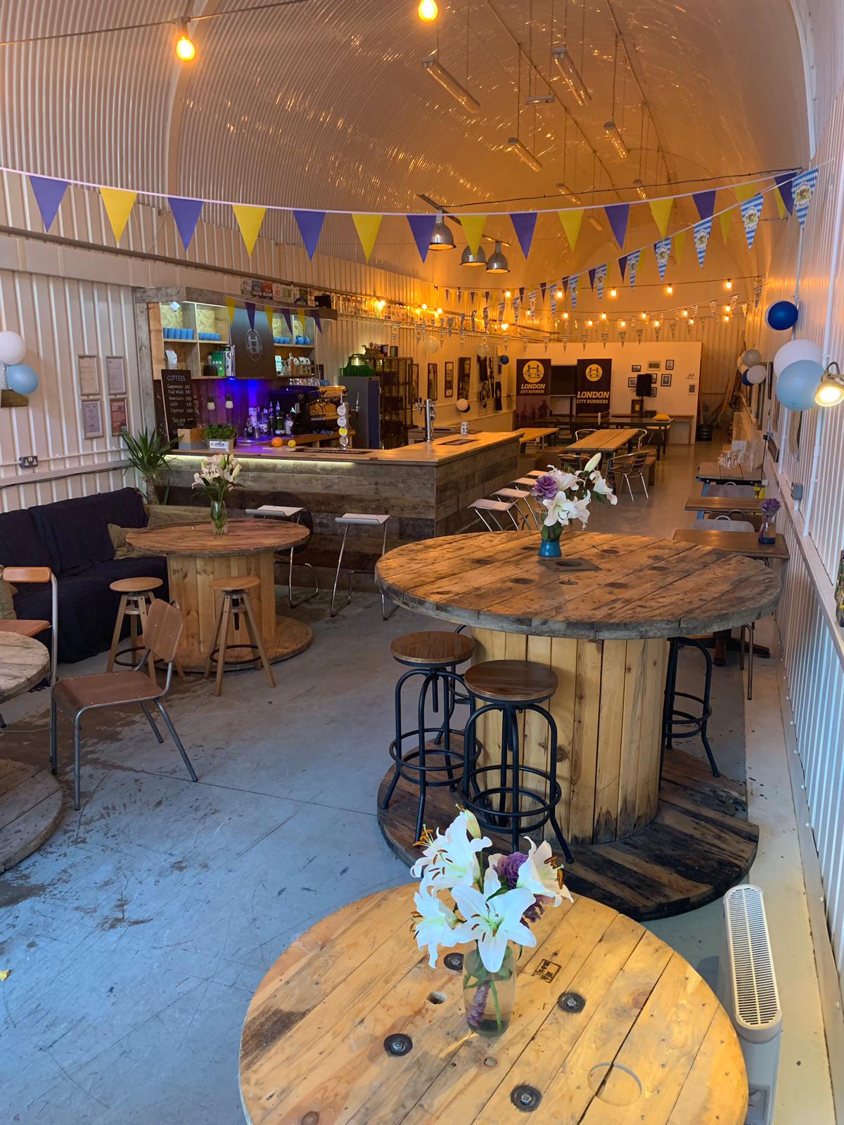 Versatile event space in London with rustic tables, ideal for gatherings and networking.