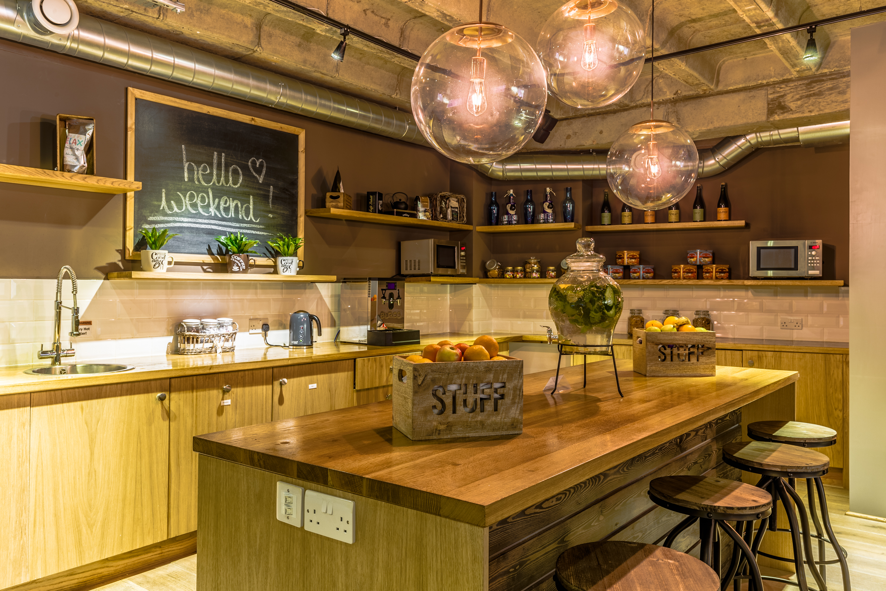 Modern kitchen venue with warm wood tones, ideal for networking events and informal gatherings.